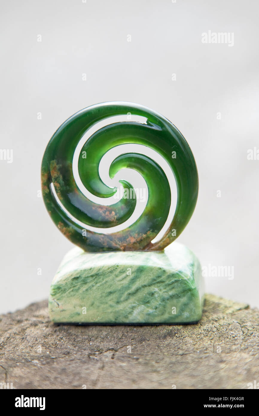 Neuseeland jade, auch genannt Grünstein oder Pounamou, in traditionelle Maori "Koru" Form ein Farnwedel Farn darzustellen geschnitzt Stockfoto