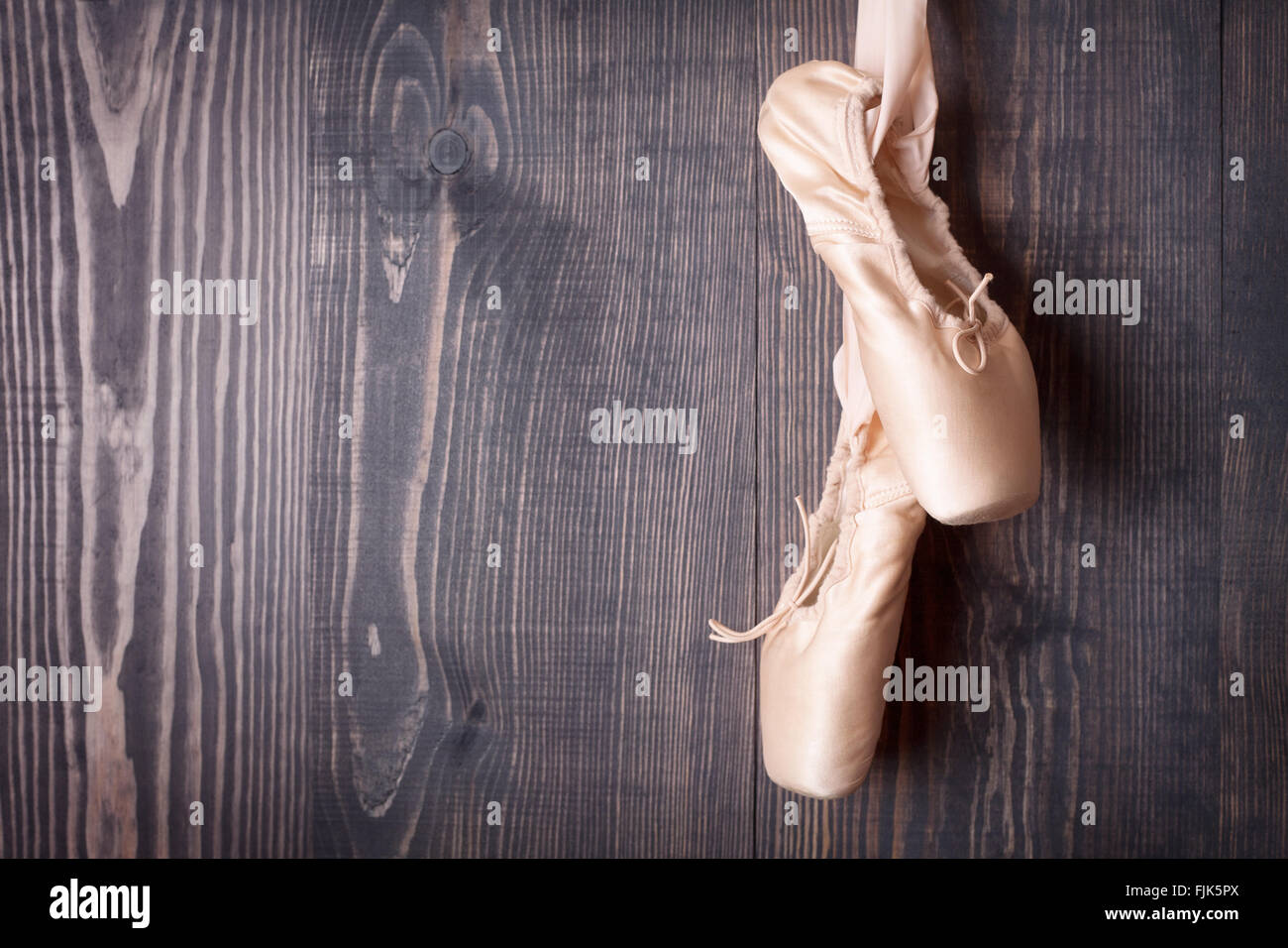 Rosa Ballettschuhe auf einem hölzernen Hintergrund Stockfoto