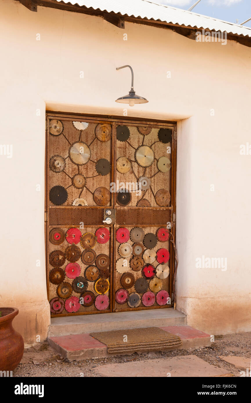 Türen mit rustikalen Holzmöbeln dekoriert mit alten Sägeblätter in Adobe Wall, Barrio Viejo, Tucson, Arizona. Einzigartige, kreative Wohnungen die lokale Architektur. Stockfoto