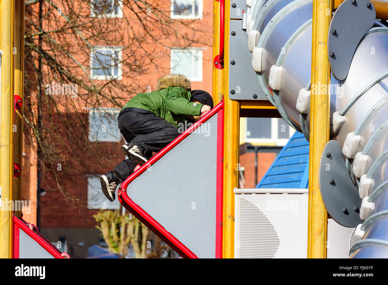 Solvesborg, Schweden - 27. Februar 2016: Ein Kind ist auf der Außenseite einer Folie aufstehen klettern. Er legt in einigen Aufwand und ist n Stockfoto