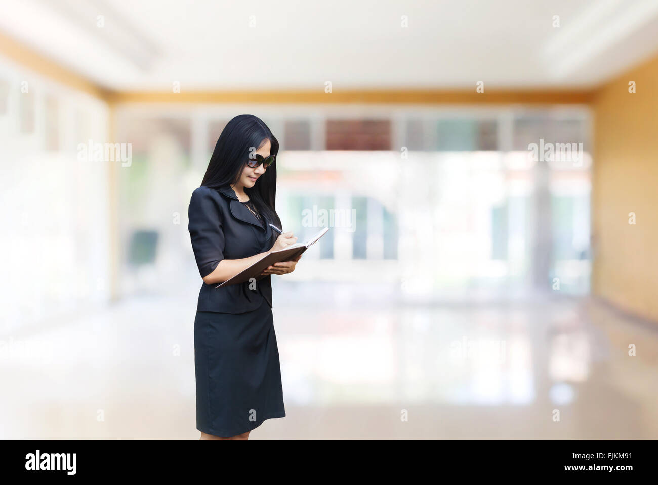 Asien-Geschäftsfrauen tragen Sonnenbrillen stehen und aufschreiben auf Notizbuch auf Kopie Raum Heimbüro Hintergrund Stockfoto