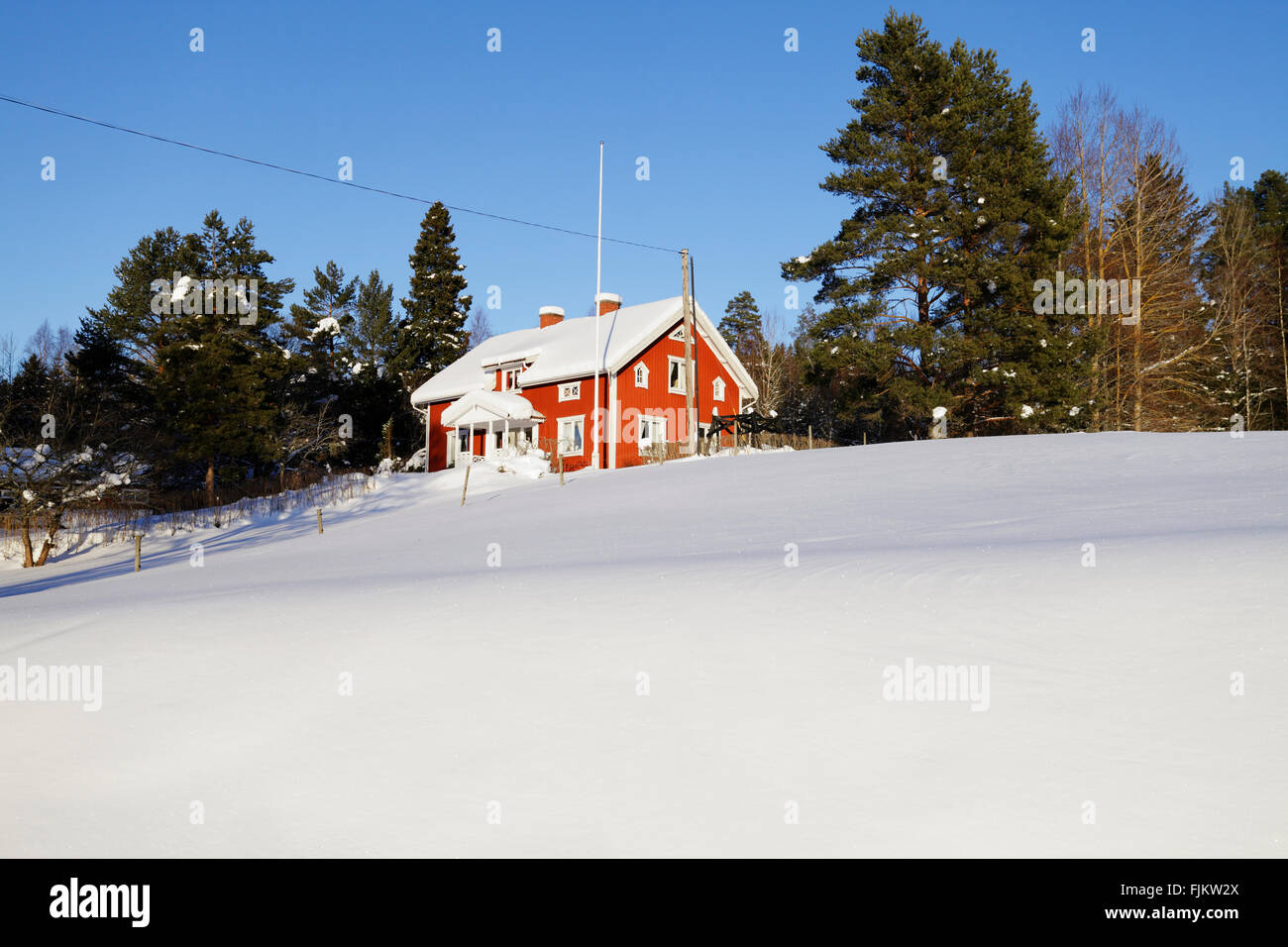 Old Red Cottage in eine verschneite Winterlandschaft Stockfoto