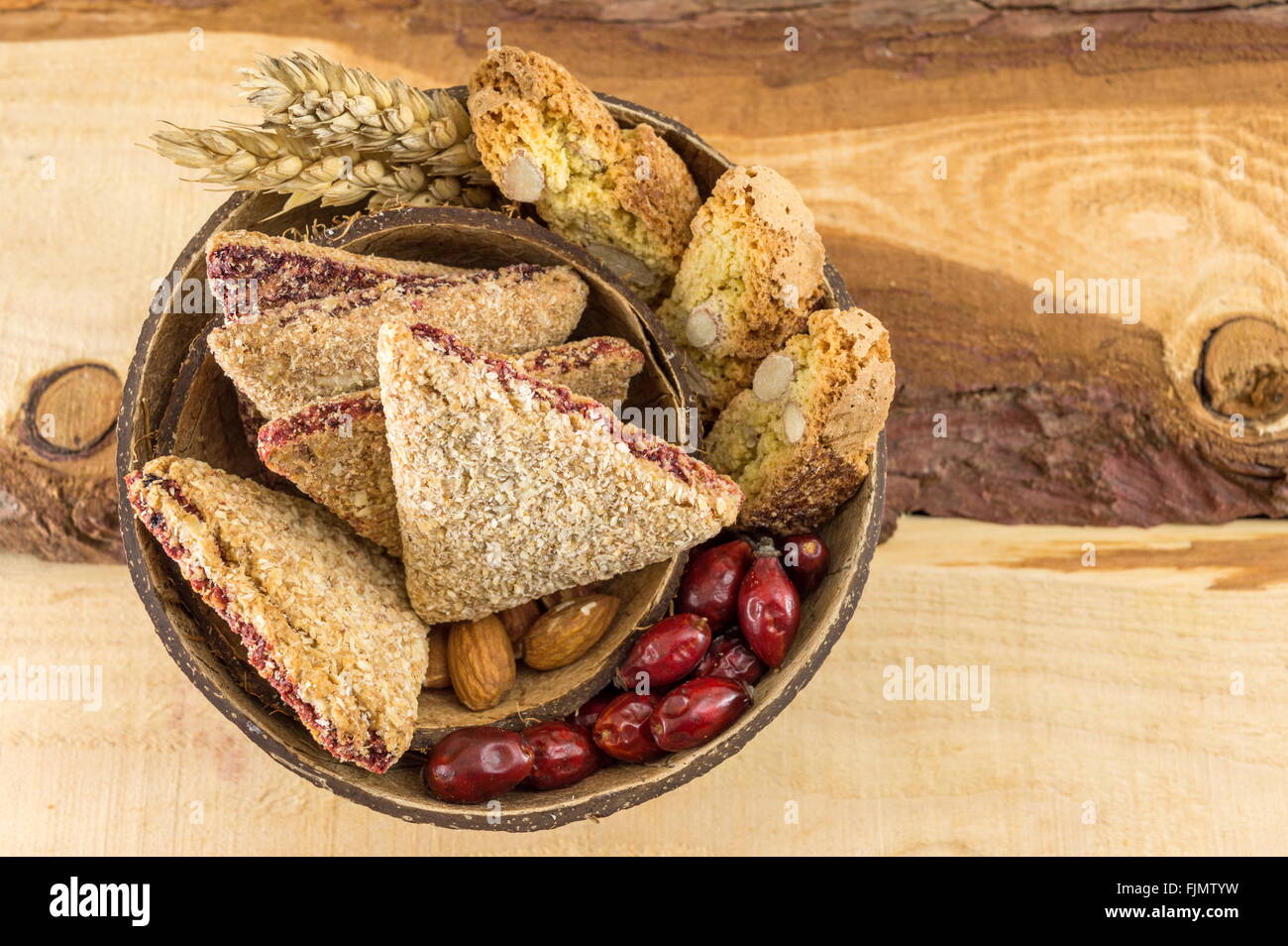 Integrale Kekse mit Mandeln und Hagebutten in einer Kokosnussschale serviert Stockfoto