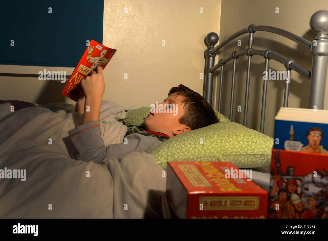 Jungen lesen im Bett, Kind, lesen ein Buch lag in seinem Bett, Gutenachtgeschichte, vor dem Schlafengehen lesen Stockfoto