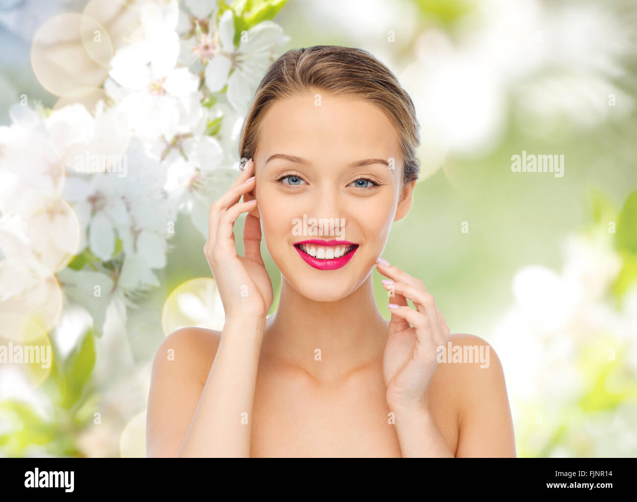 lächelnde junge Frau mit rosa Lippenstift auf den Lippen Stockfoto