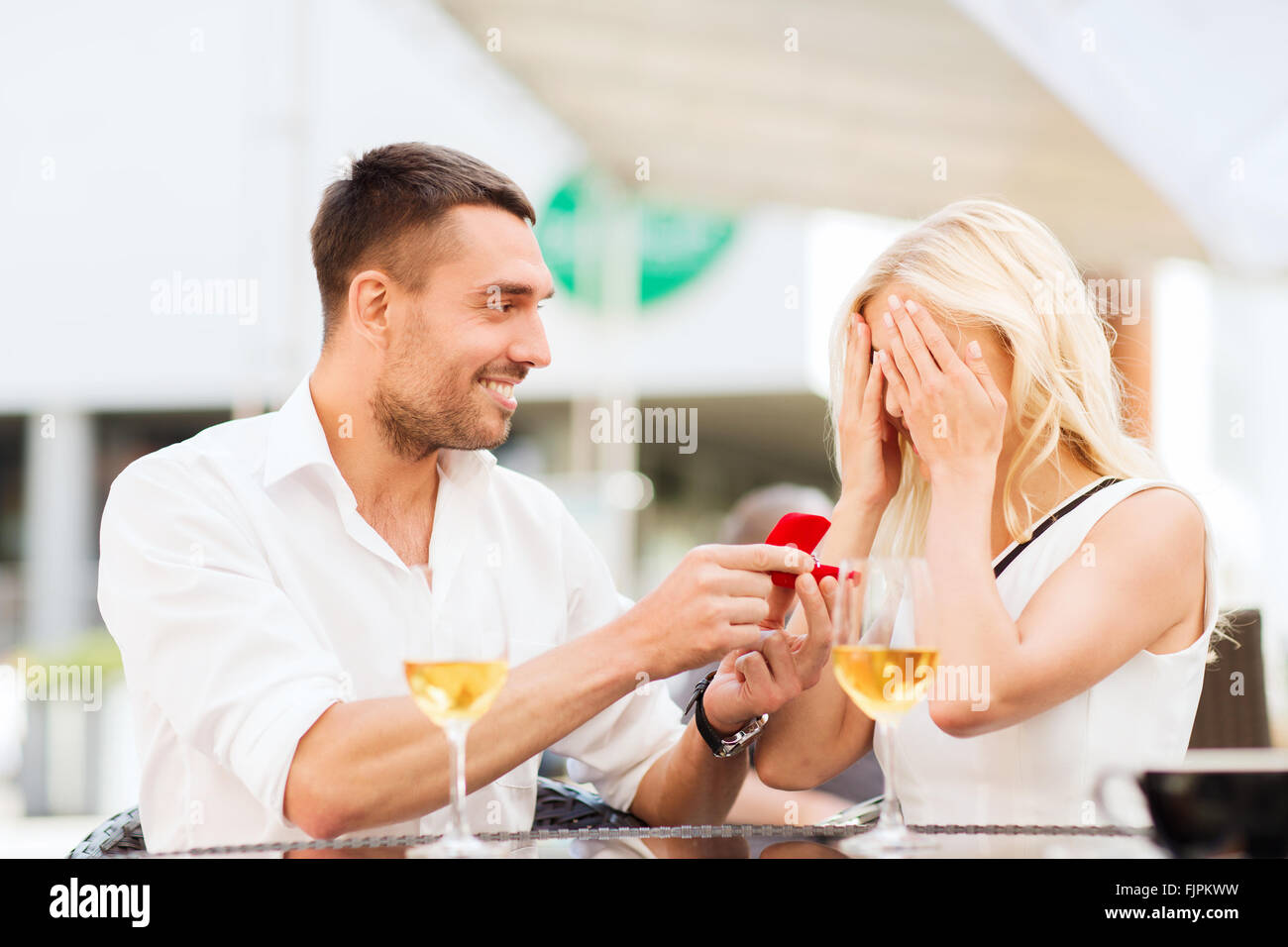 Brautpaar mit Verlobungsring und Wein im café Stockfoto