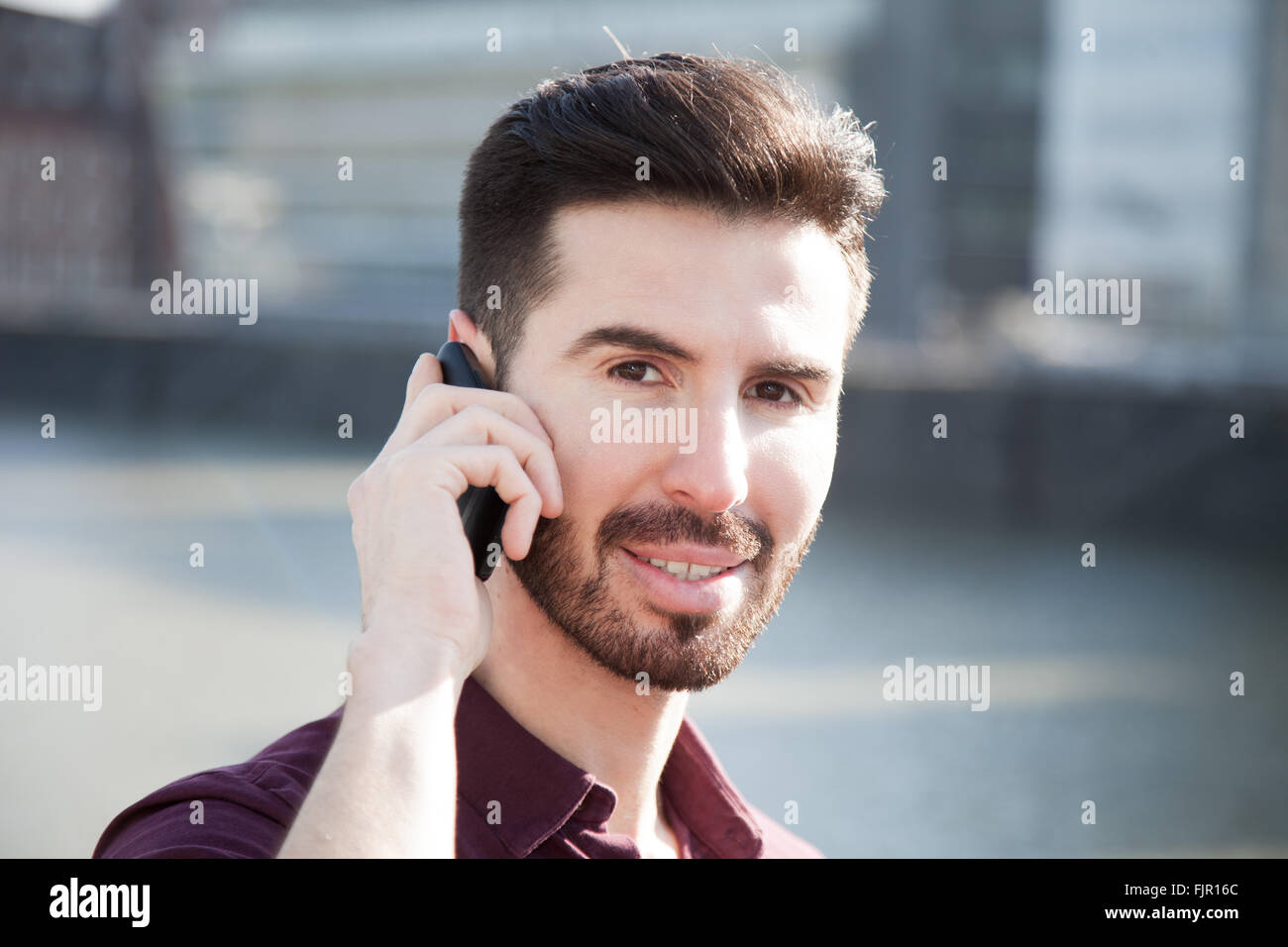 Attraktiver junger Mann mit Smartphone Stockfoto