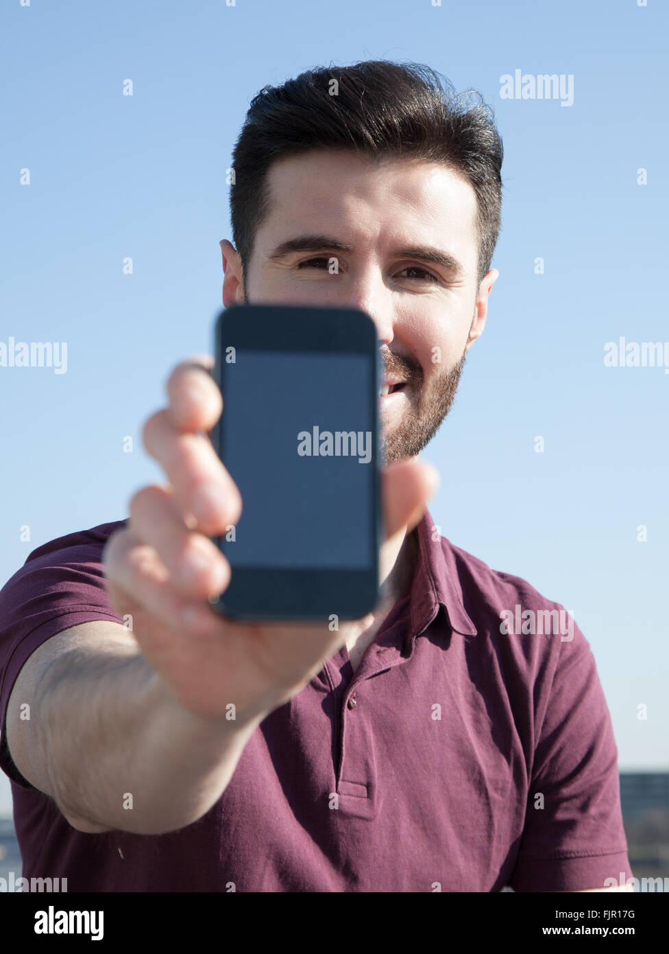 Attraktive junge Mann hält Smartphone Stockfoto