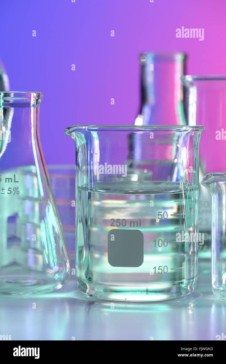 Becher mit klarer Flüssigkeit auf Labortisch Stockfoto