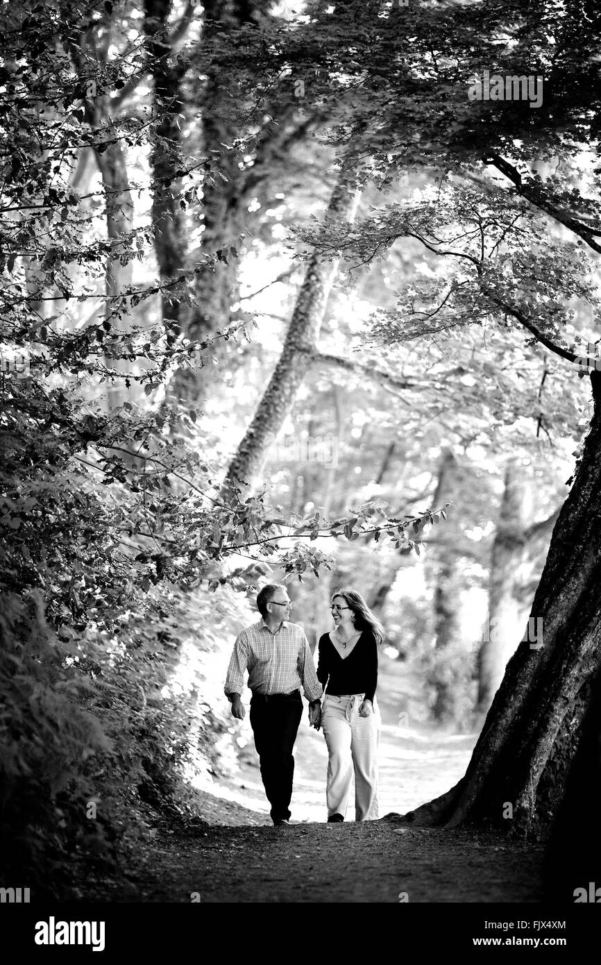 Paar im Wald, umgeben von Natur, Hand in Hand Stockfoto