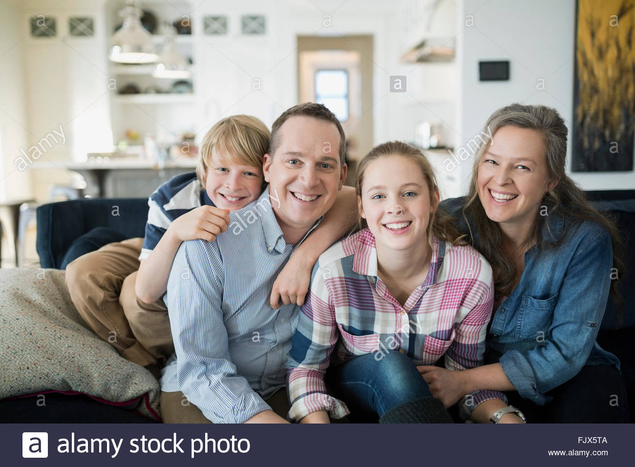 Porträt, Lächeln Familie auf dem Sofa im Wohnzimmer Stockfoto