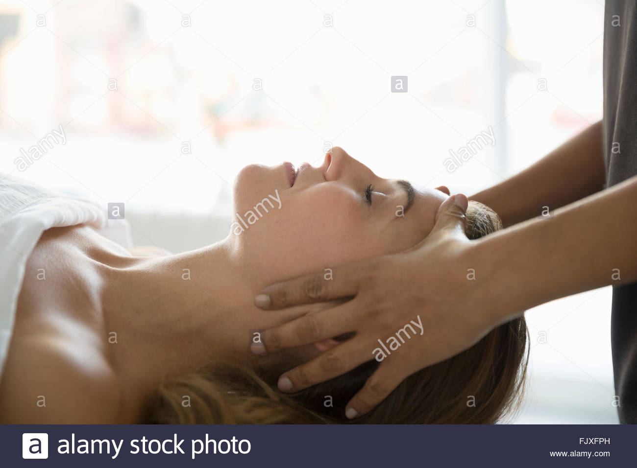 Heitere Frau mit Augen geschlossen empfangenden Kopfmassage Stockfoto