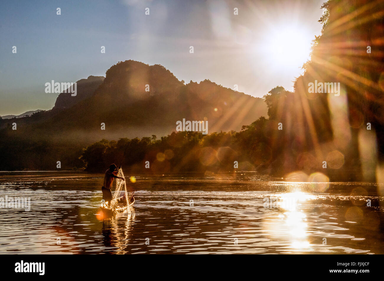 Asien. Süd-Ost-Asien. Laos. Provinz von Luang Prabang entfernt. Fischer am Mekong Fluss bei Sonnenuntergang. Stockfoto