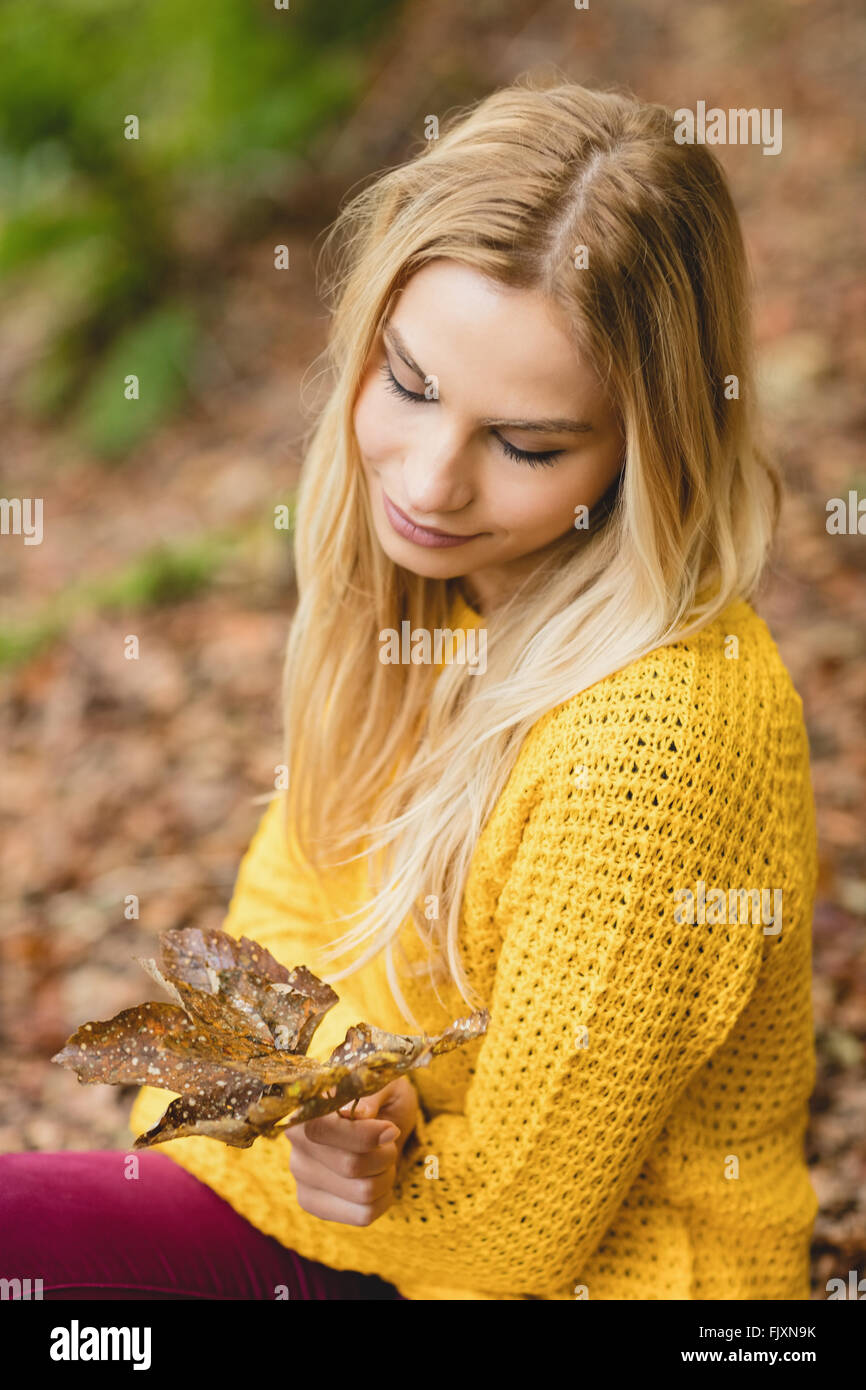 Schöne blonde Frau auf dem Boden sitzend Stockfoto