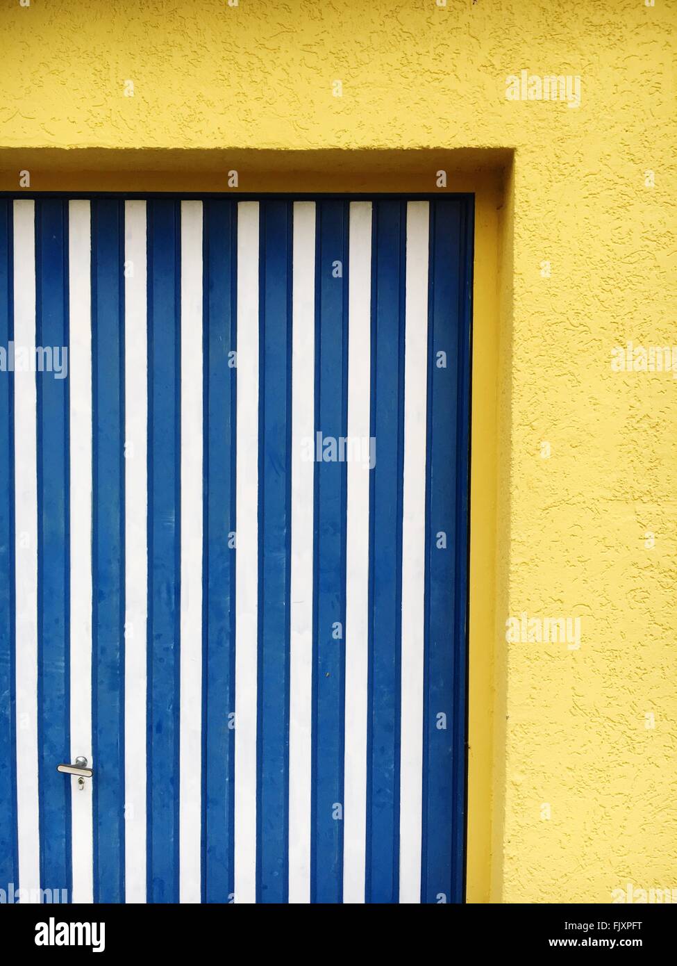 Blau gestreifte Tür auf gelbe Haus Stockfoto
