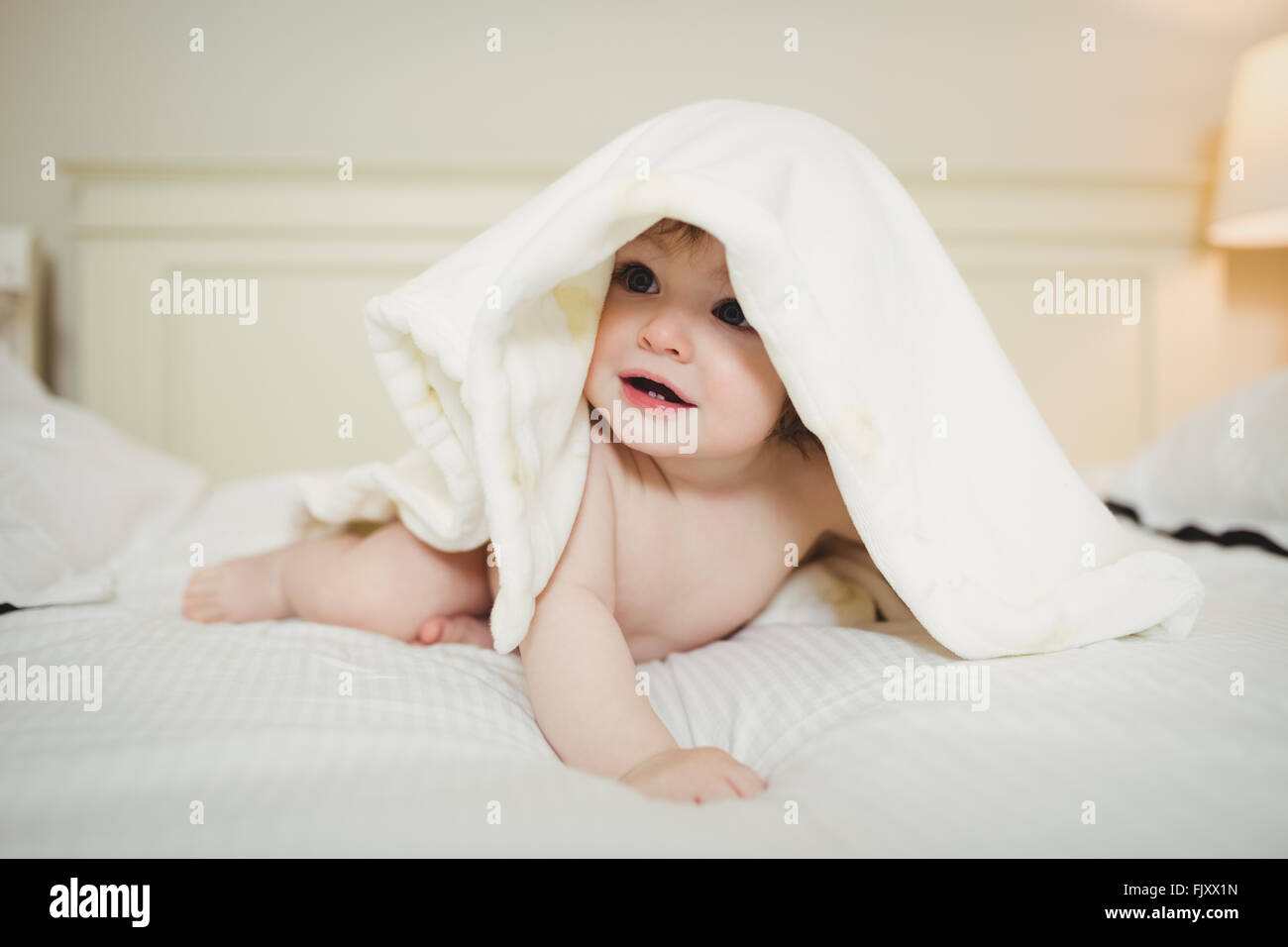 Niedliche Baby versteckt unter einer Decke Stockfoto