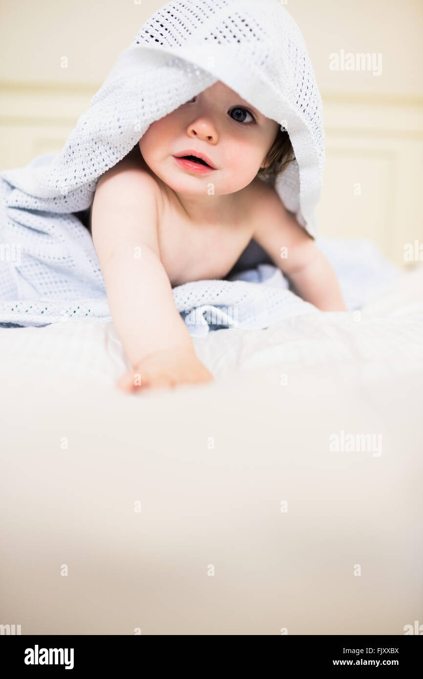 Niedliche Baby versteckt unter einer Decke Stockfoto