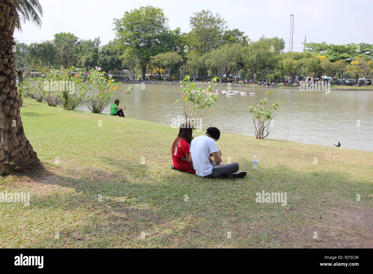 Paare sitzen an einem See, Chatuchak Park, Bangkok, Thailand Stockfoto