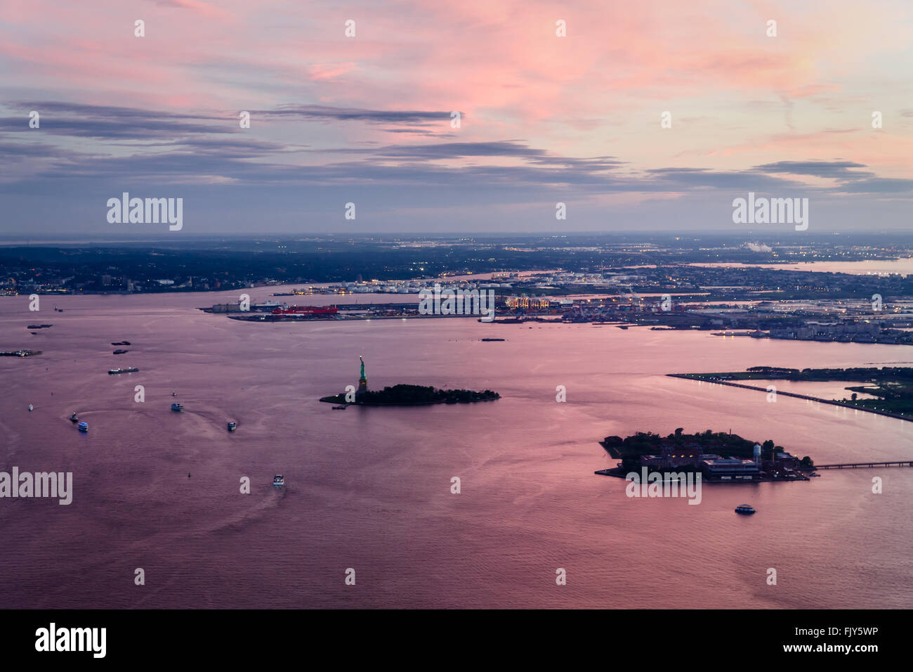 Luftaufnahme von Manhattan, Ellis Island, die Freiheitsstatue, Liberty Port in New Jersey mit rosa Sonnenuntergang Reflektionen Stockfoto