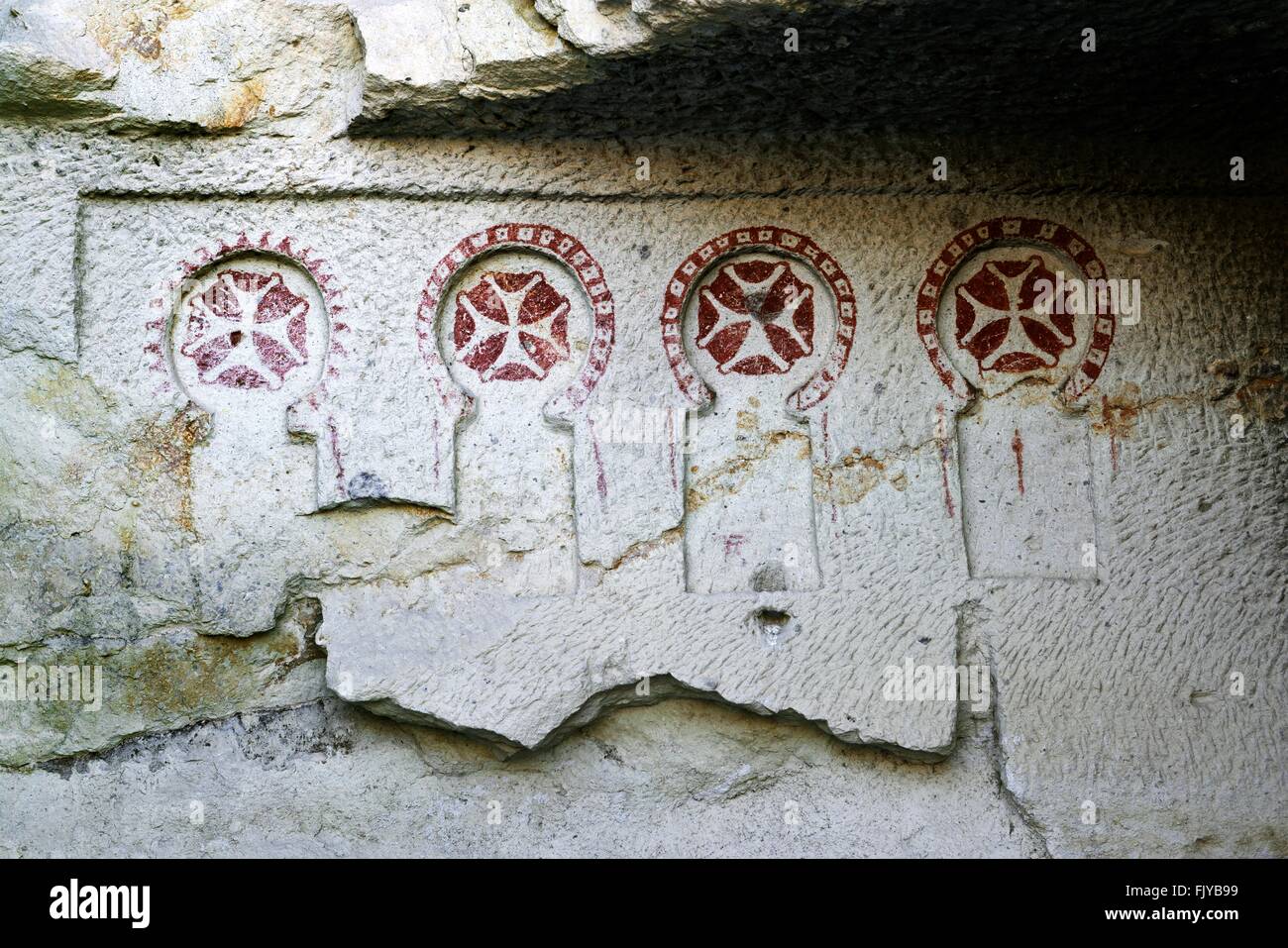 Bemalte frühe christliche Kreuze geschnitzt. Abgefressenen vulkanischen Tuff Felswand. Göreme Open Air Museum Nationalpark, Cappadocia Türkei Stockfoto