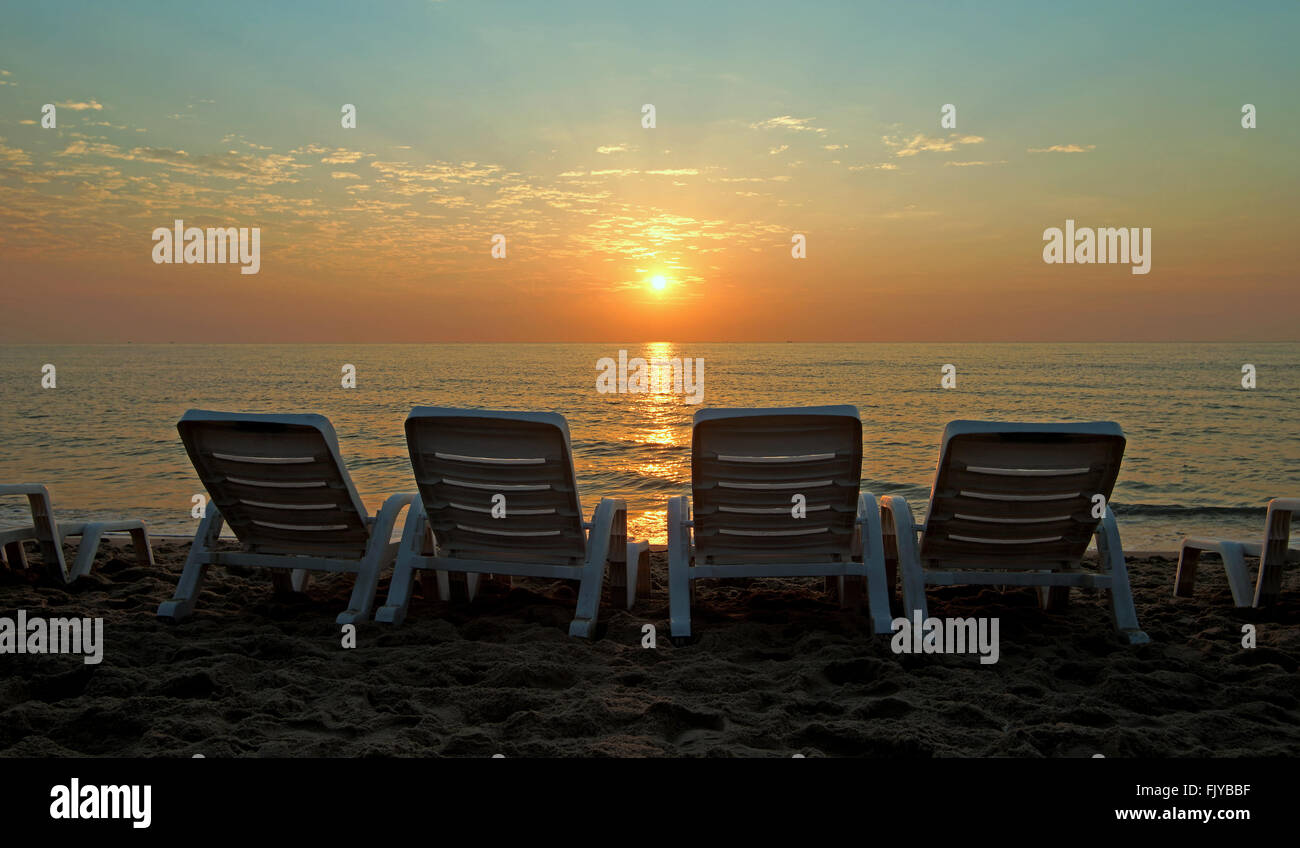 Liege am Strand mit wunderschönen Sonnenaufgang Hintergrund Stockfoto