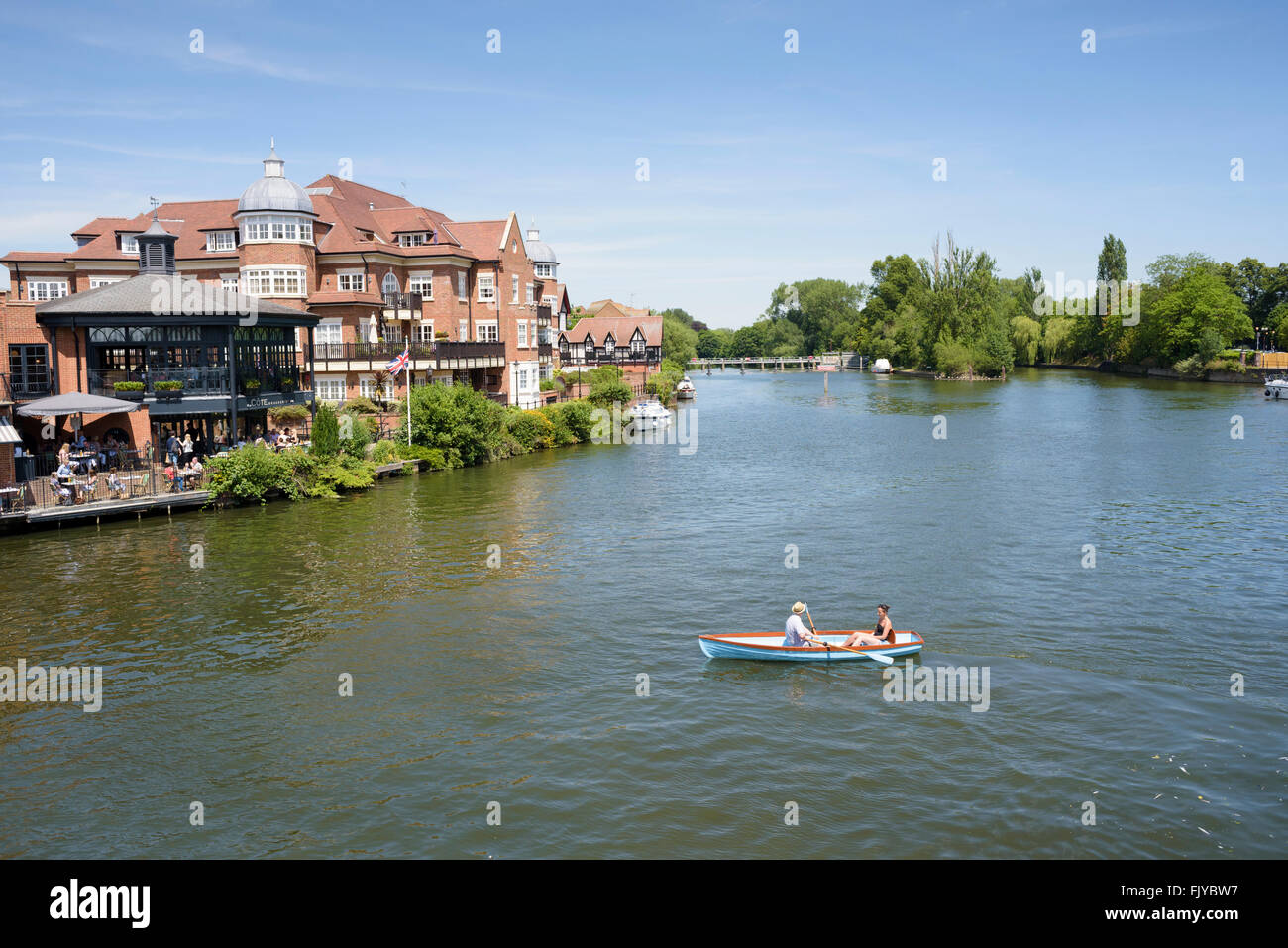 Ein Mann und eine Frau ist ein Ruderboot auf der Themse in Windsor/Eton in der Nähe von Romney Lock. Stockfoto