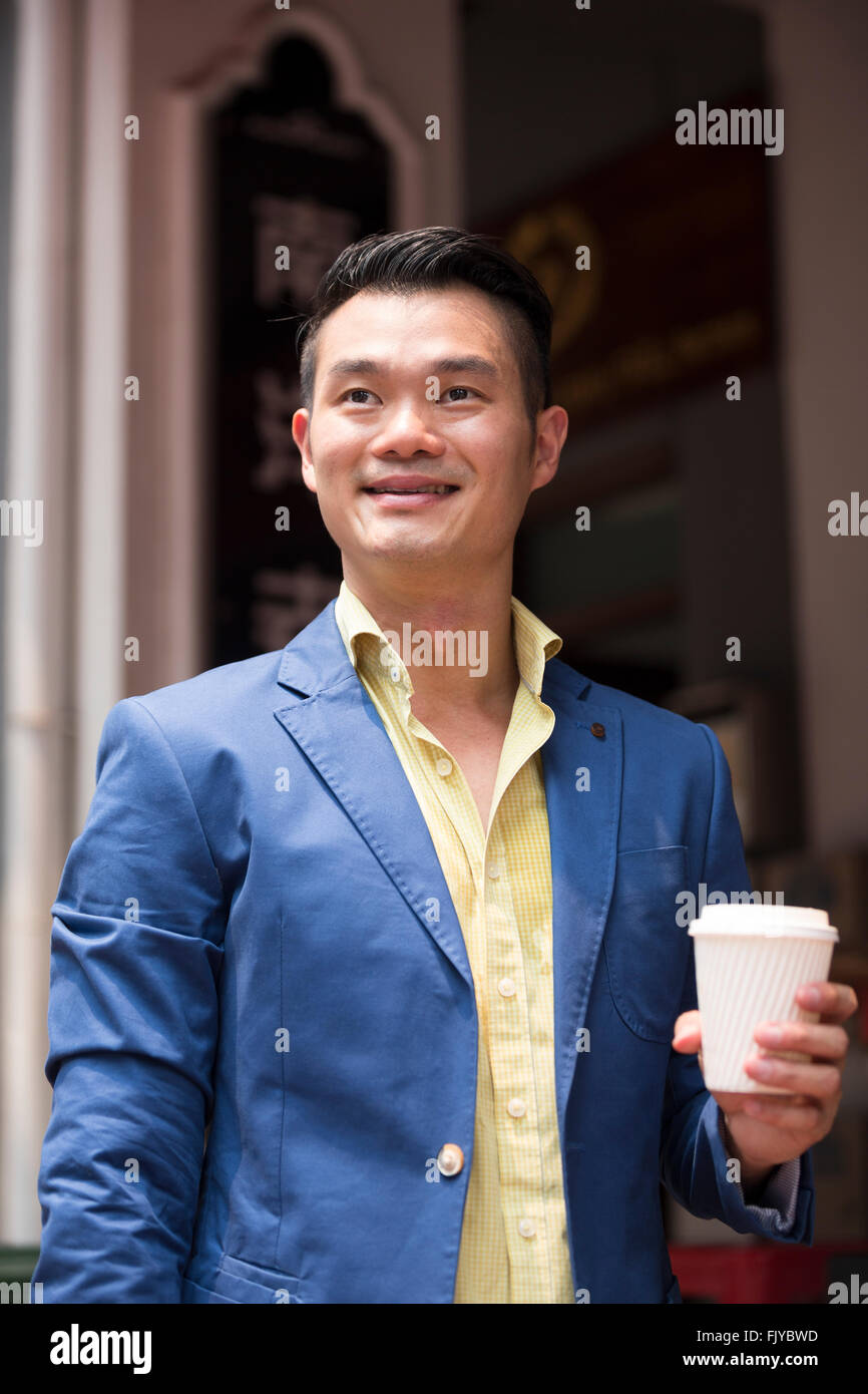 Porträt eines angesagten urbanen chinesischen Mann. Glücklich asiatischer Mann in der Stadt mit Blick von der Kamera entfernt. Stockfoto