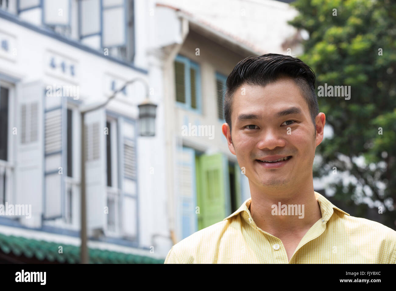 Porträt eines angesagten urbanen chinesischen Mann. Glücklich asiatischer Mann in der Stadt mit Blick von der Kamera entfernt. Stockfoto