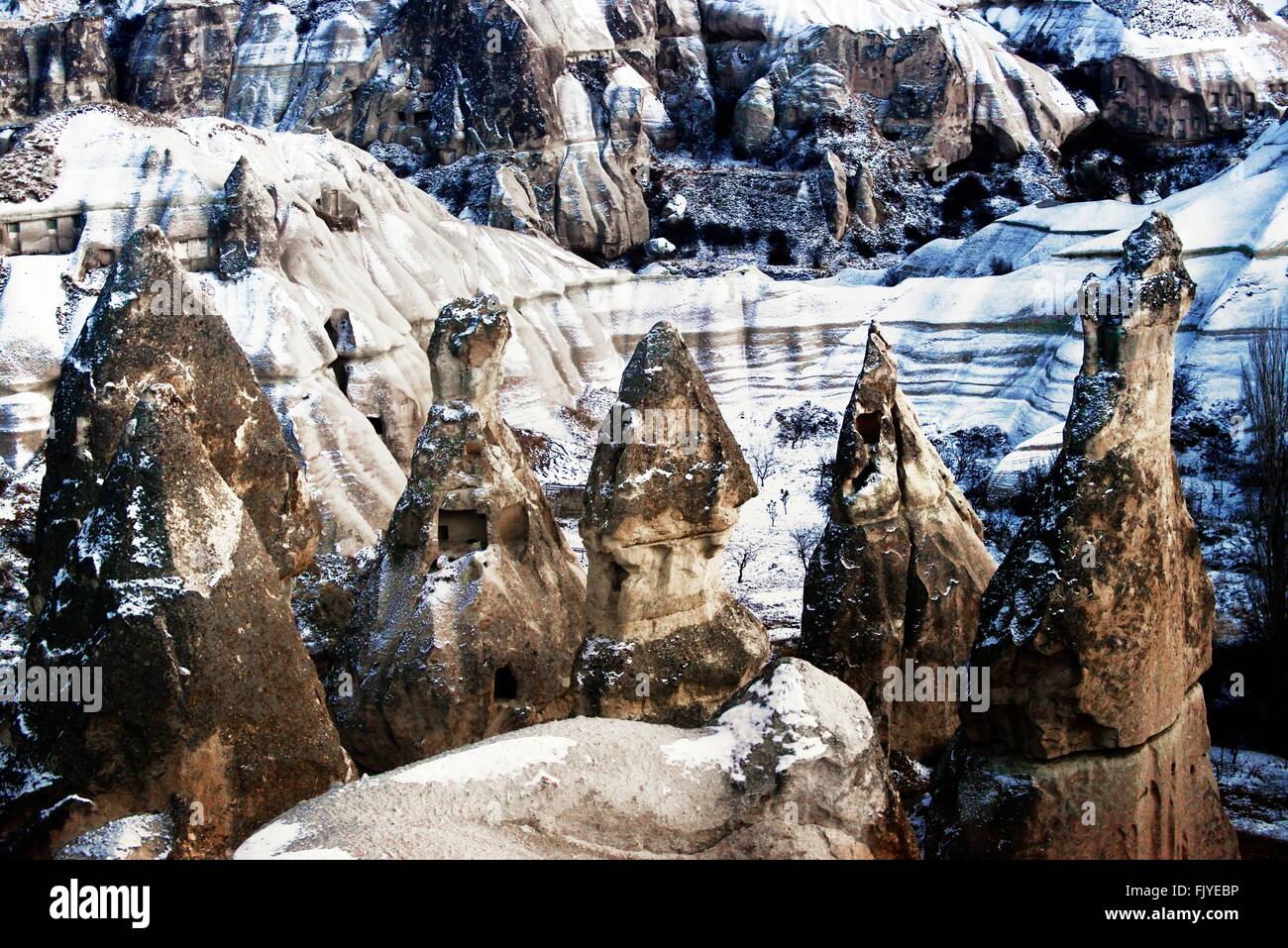 Abgefressenen vulkanischen Tuffstein Säulen Fee Schornsteine Hoodoos im Nationalpark Göreme, Kappadokien, Türkei. Winterschnee Stockfoto