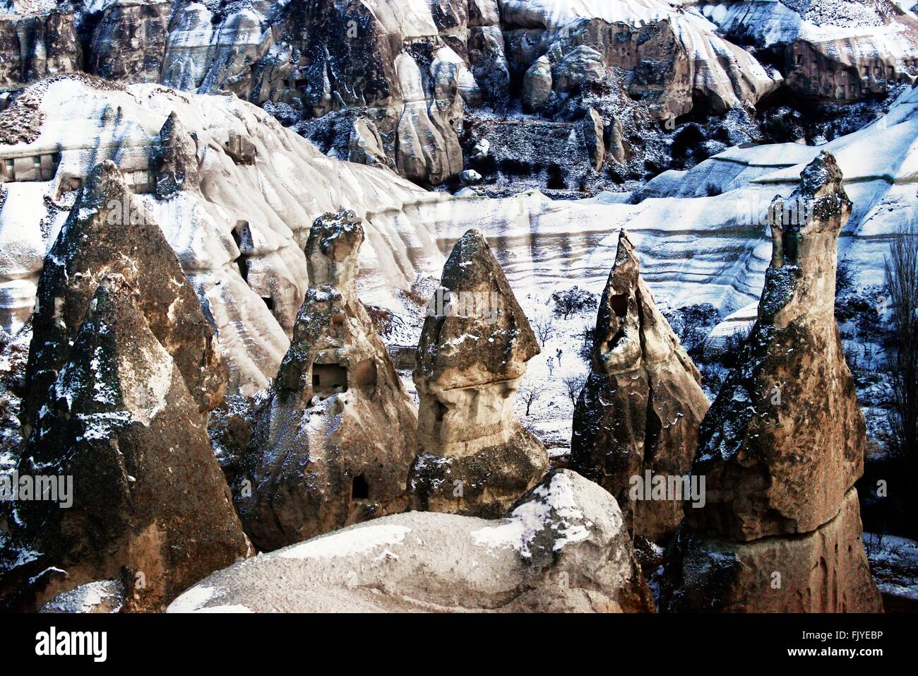 Erodiert vulkanischen Tuff rock Säulen Feenkamine Hoodoos im Nationalpark Göreme in Kappadokien, Türkei. winter schnee Stockfoto