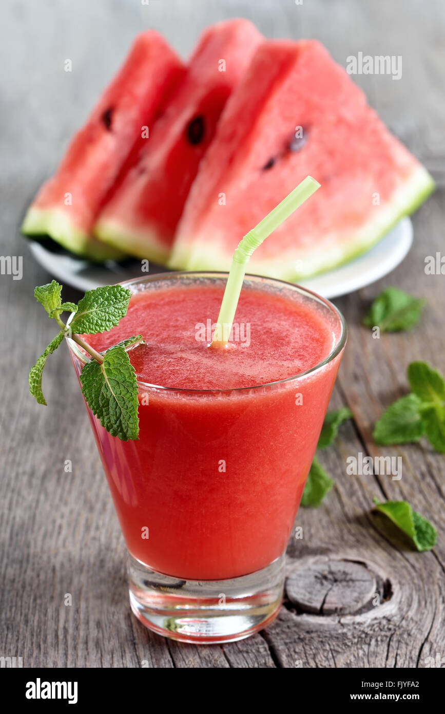 Wassermelonensaft und Slice auf hölzernen Hintergrund Stockfoto