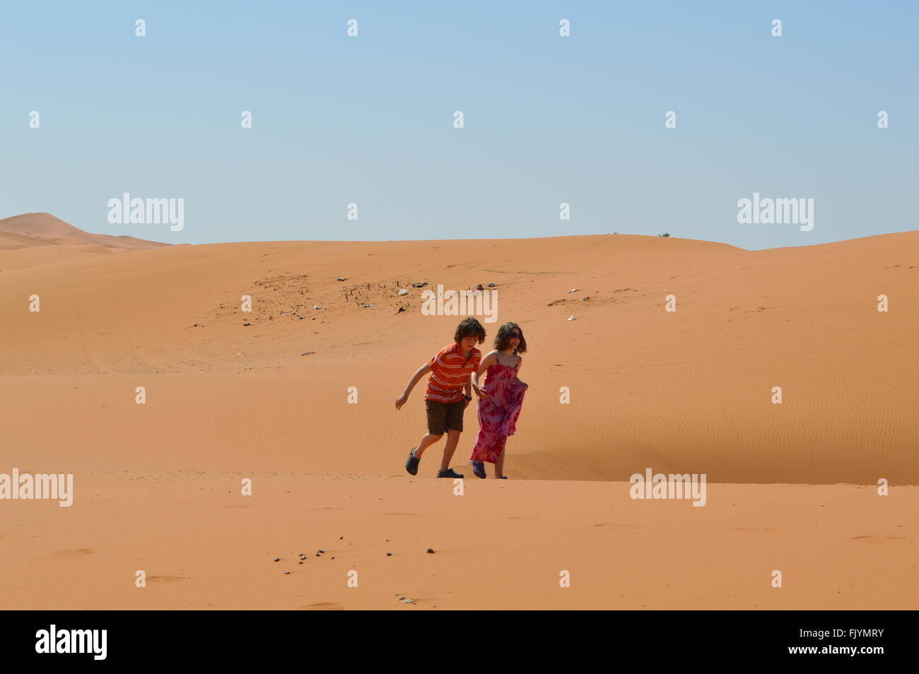 Kinder laufen in Sanddünen in der Sahara Stockfoto