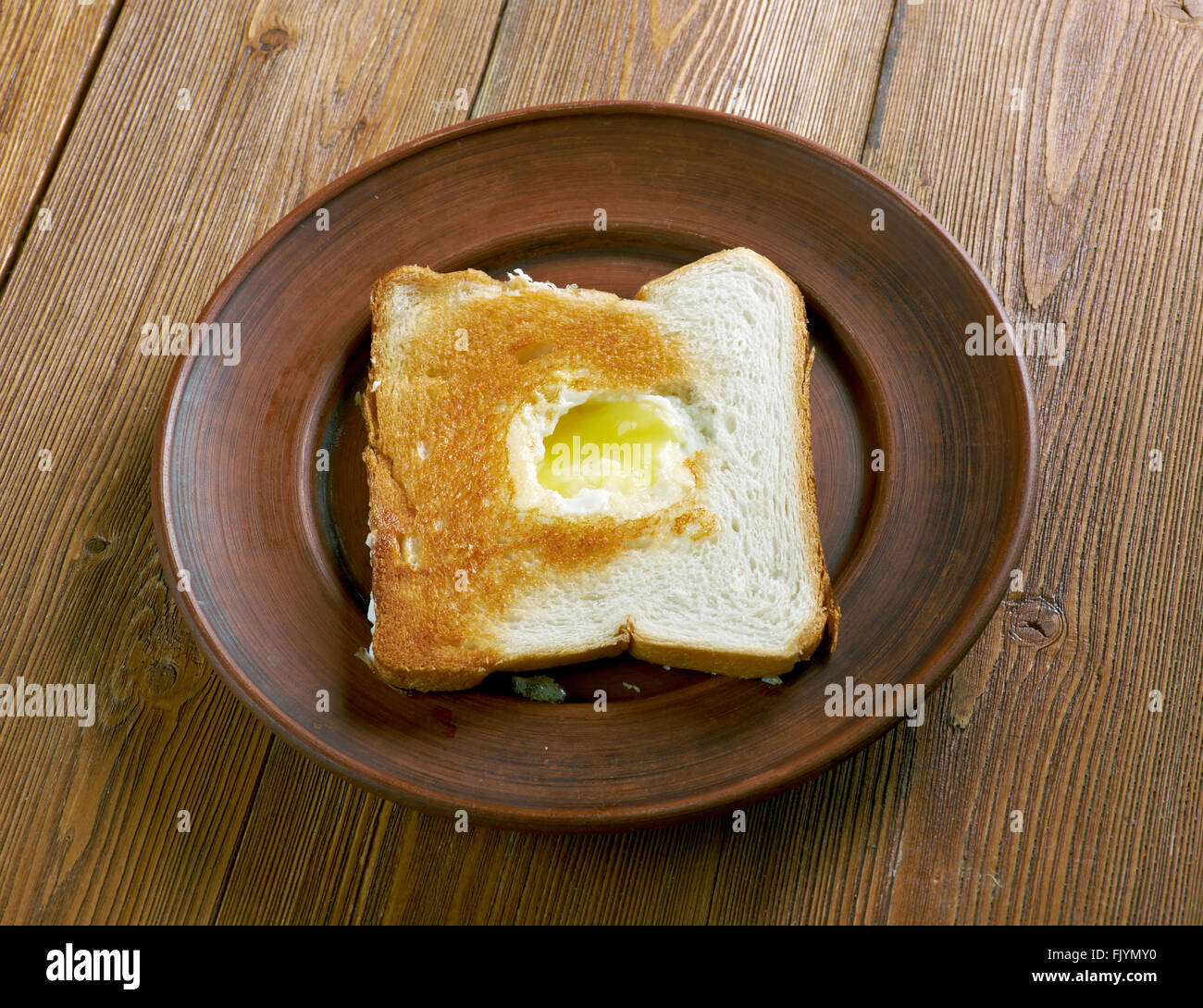 Ei im Korb - Ei in ein Loch mit einem Stück Brot gebraten. Stockfoto