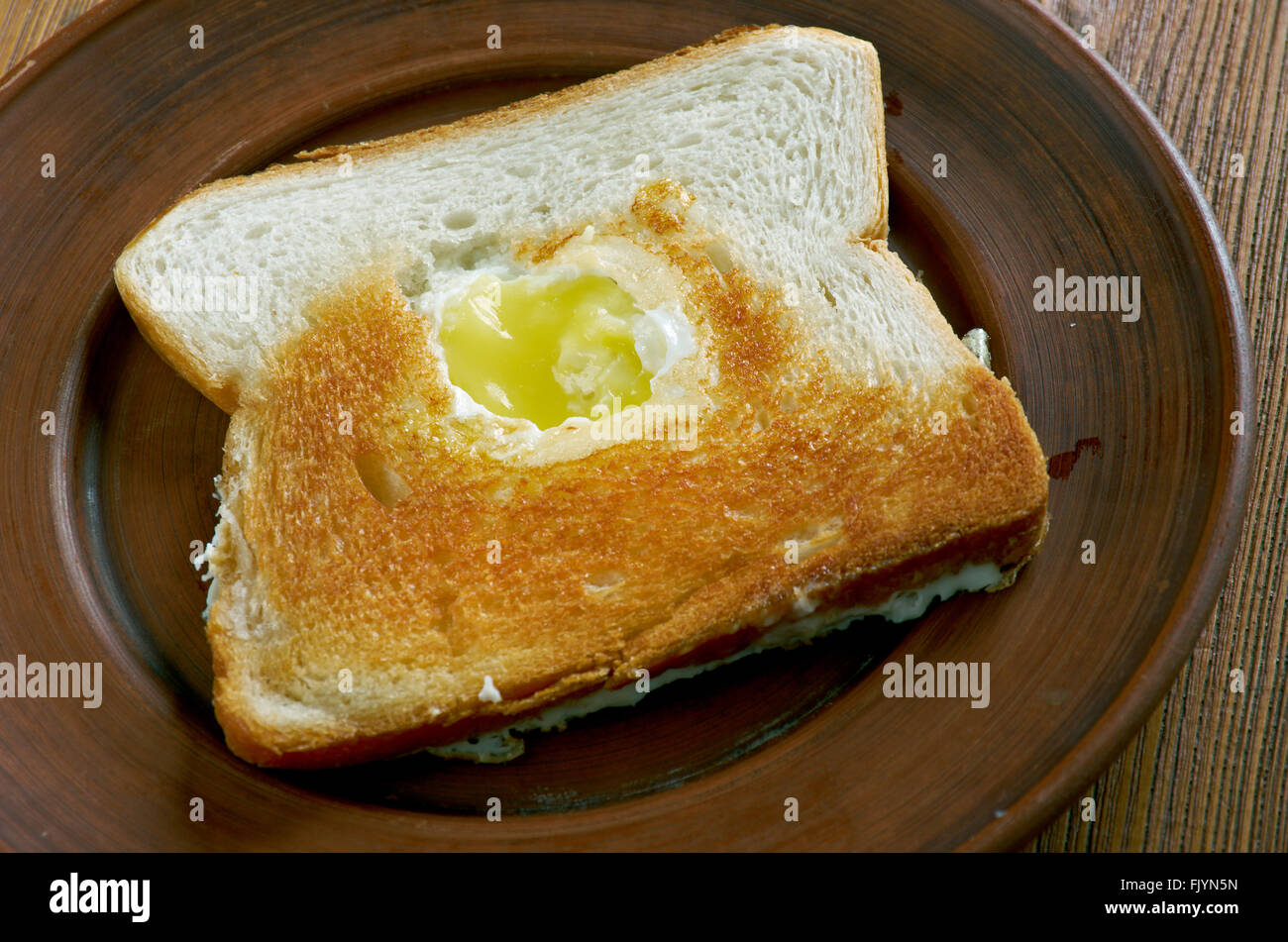 Ei im Korb - Ei in ein Loch mit einem Stück Brot gebraten. Stockfoto