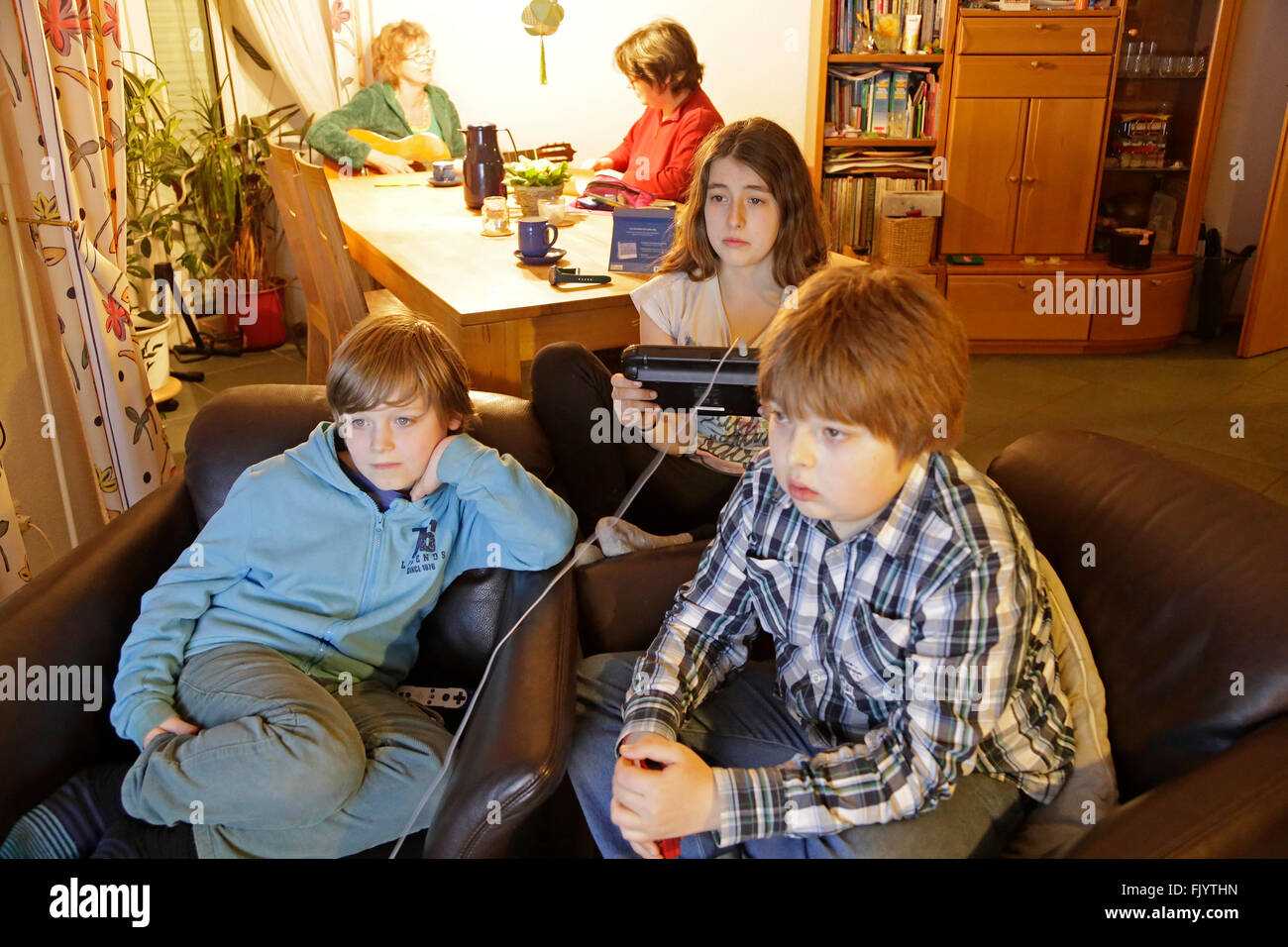 Kinder spielen Wii U, während ihre Mütter sind einen chat Stockfoto