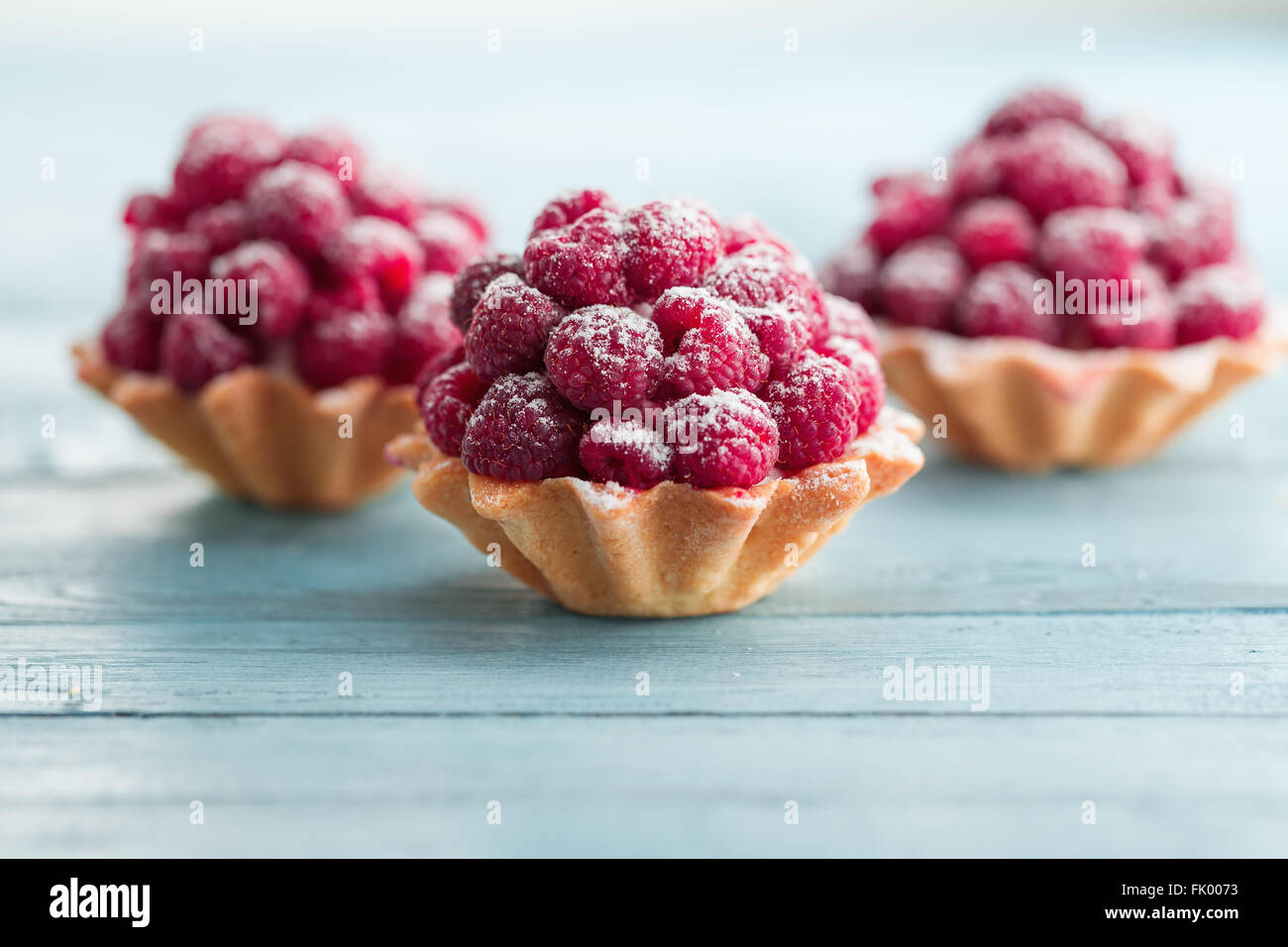 Himbeer Törtchen mit Creme füllen und mit Puderzucker bestäubt Stockfoto