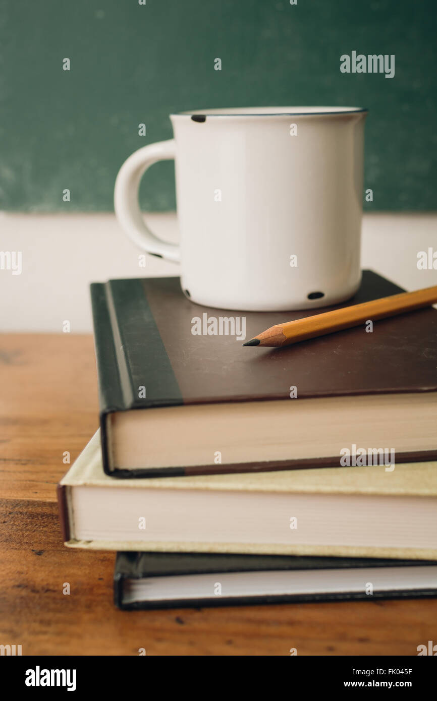 Bleistift mit Kaffee und Stapel Bücher Stockfoto