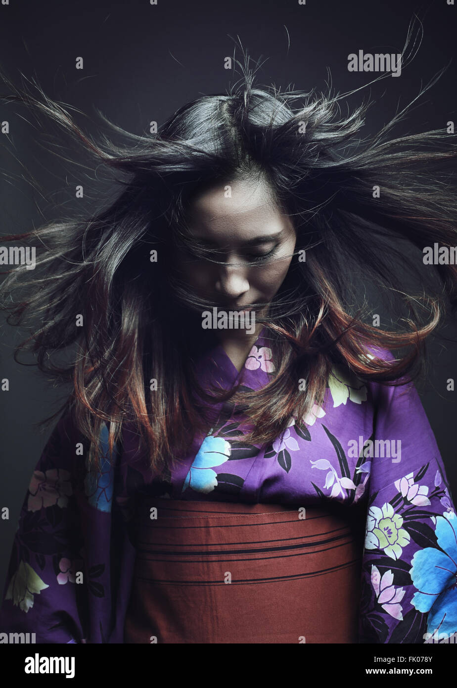 Porträt einer japanischen Frau mit traditionellen Kimono. Dunkle Studioaufnahme Stockfoto