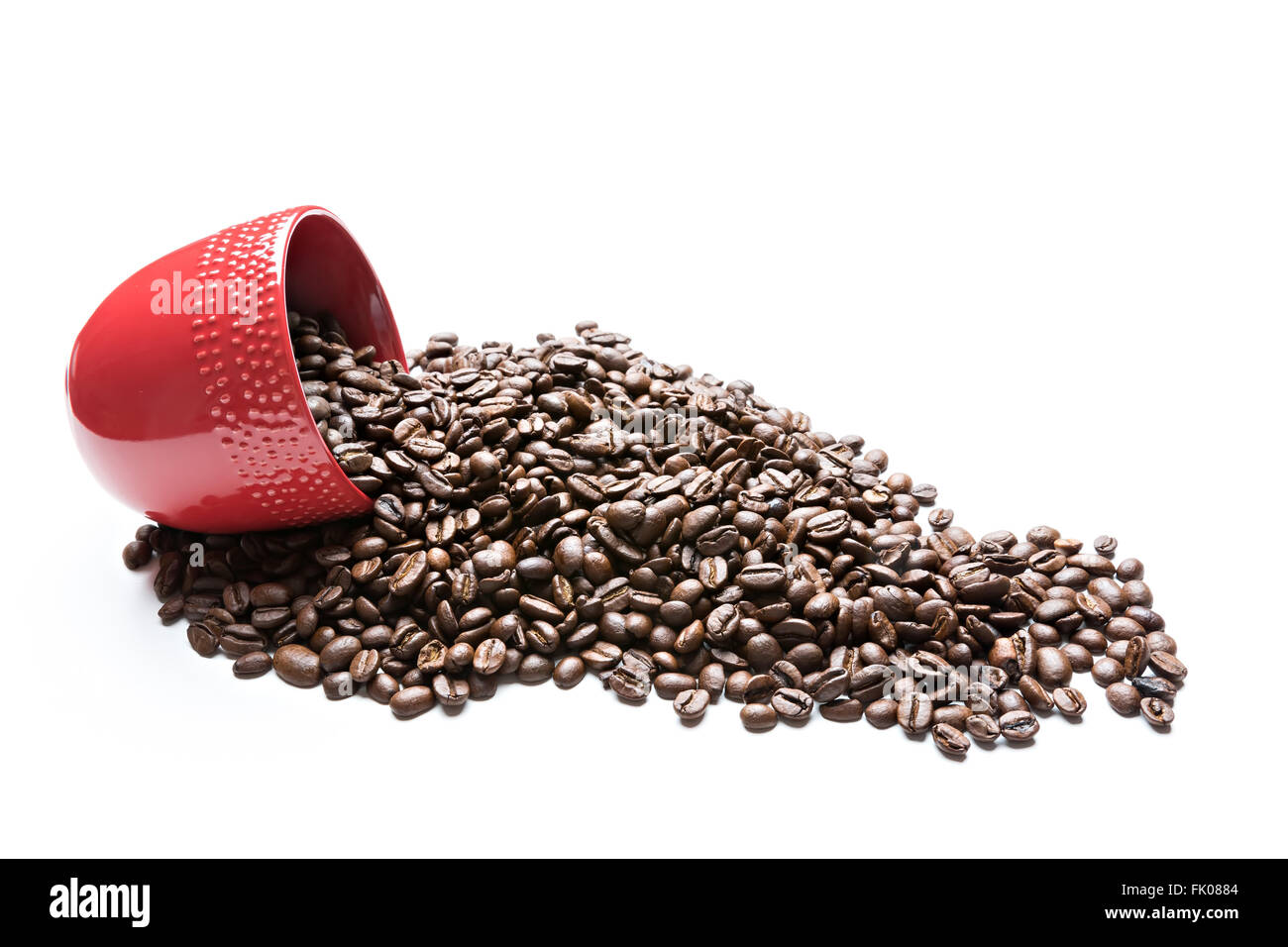 Rote Tasse gefüllt mit Kaffeebohnen isoliert auf weiss Stockfoto