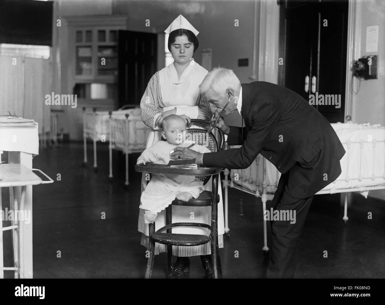 Arzt mit Krankenschwester untersuchen Baby im Krankenhaus, USA, 1915 Stockfoto