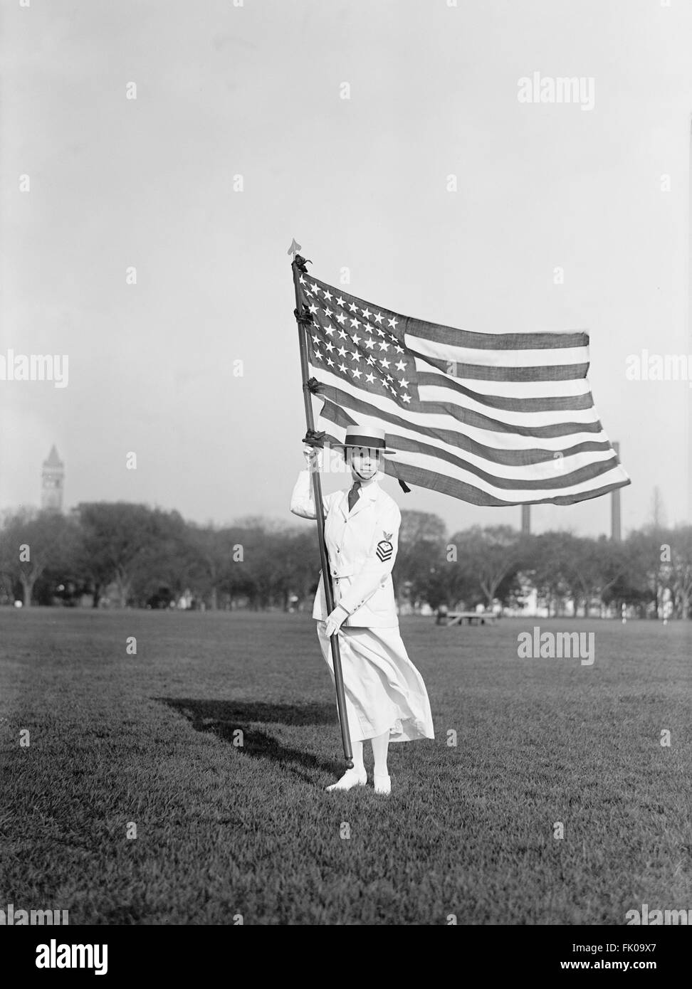 Weibliche Marine Yeoman im weißen Sommerkleid Uniform mit der amerikanischen Flagge, USA, ca. 1917 Stockfoto