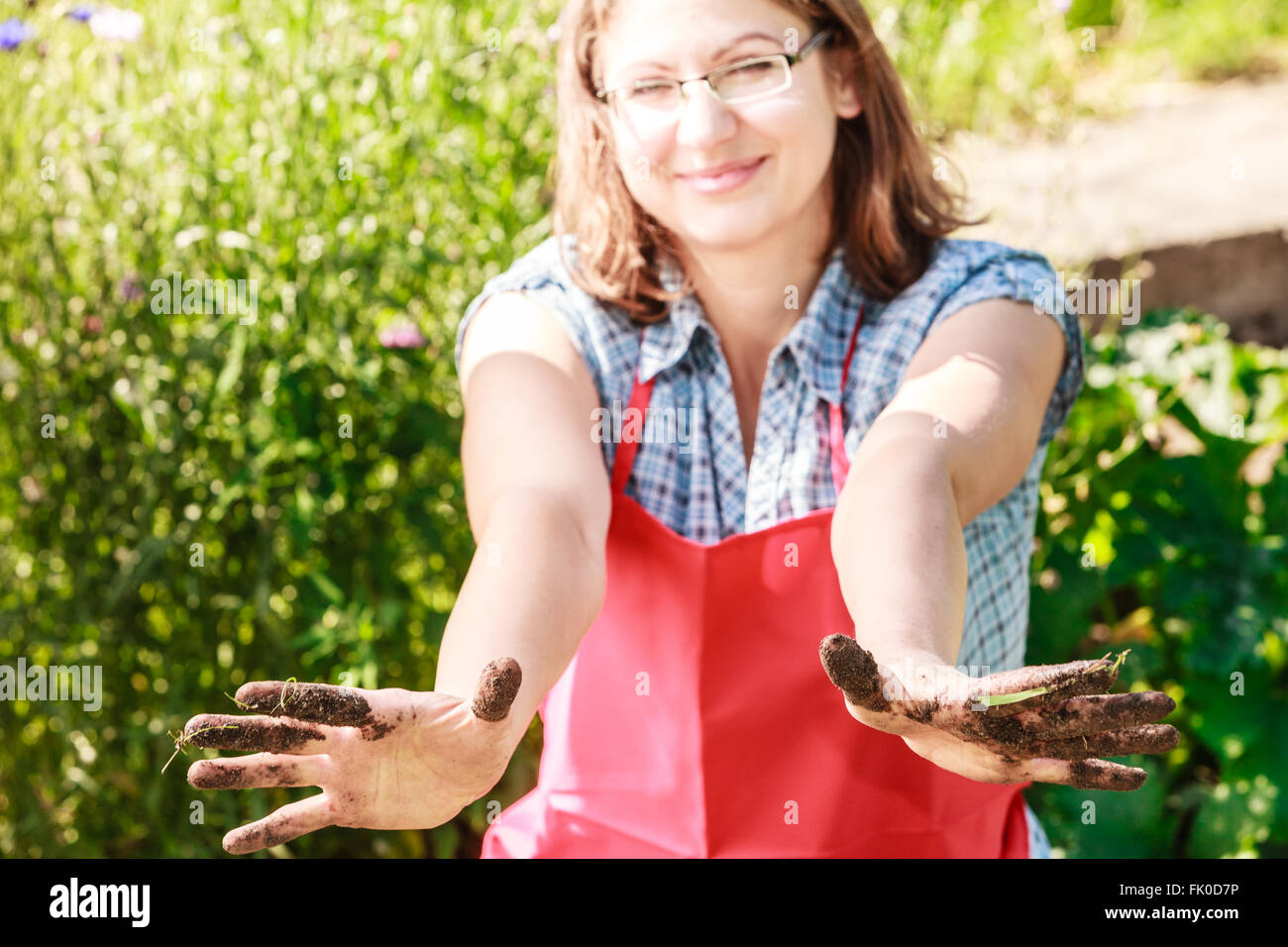 Reife lustige Frau Gärtner trägt Schürze arbeiten im Garten zeigt