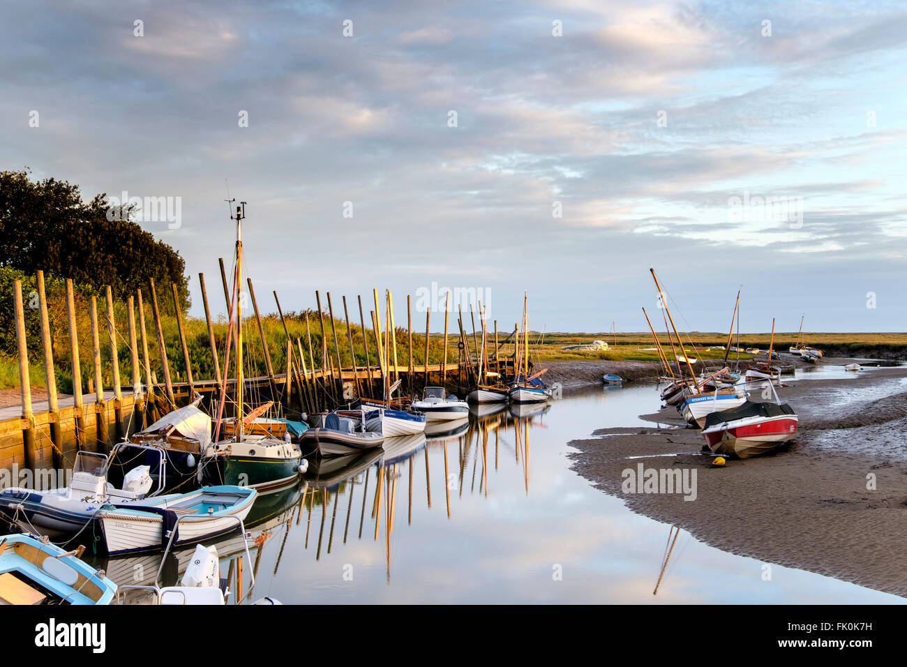 Reflexionen von Booten an einem ruhigen Morgen am Blakeney beherbergen. Stockfoto