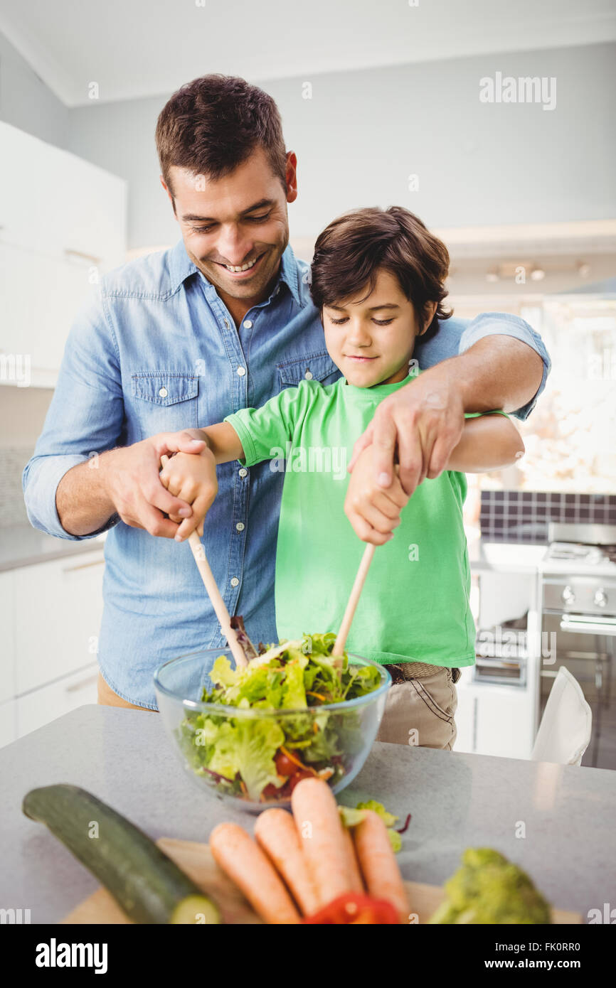 Glücklicher Vater und Sohn bereitet Salat Stockfoto