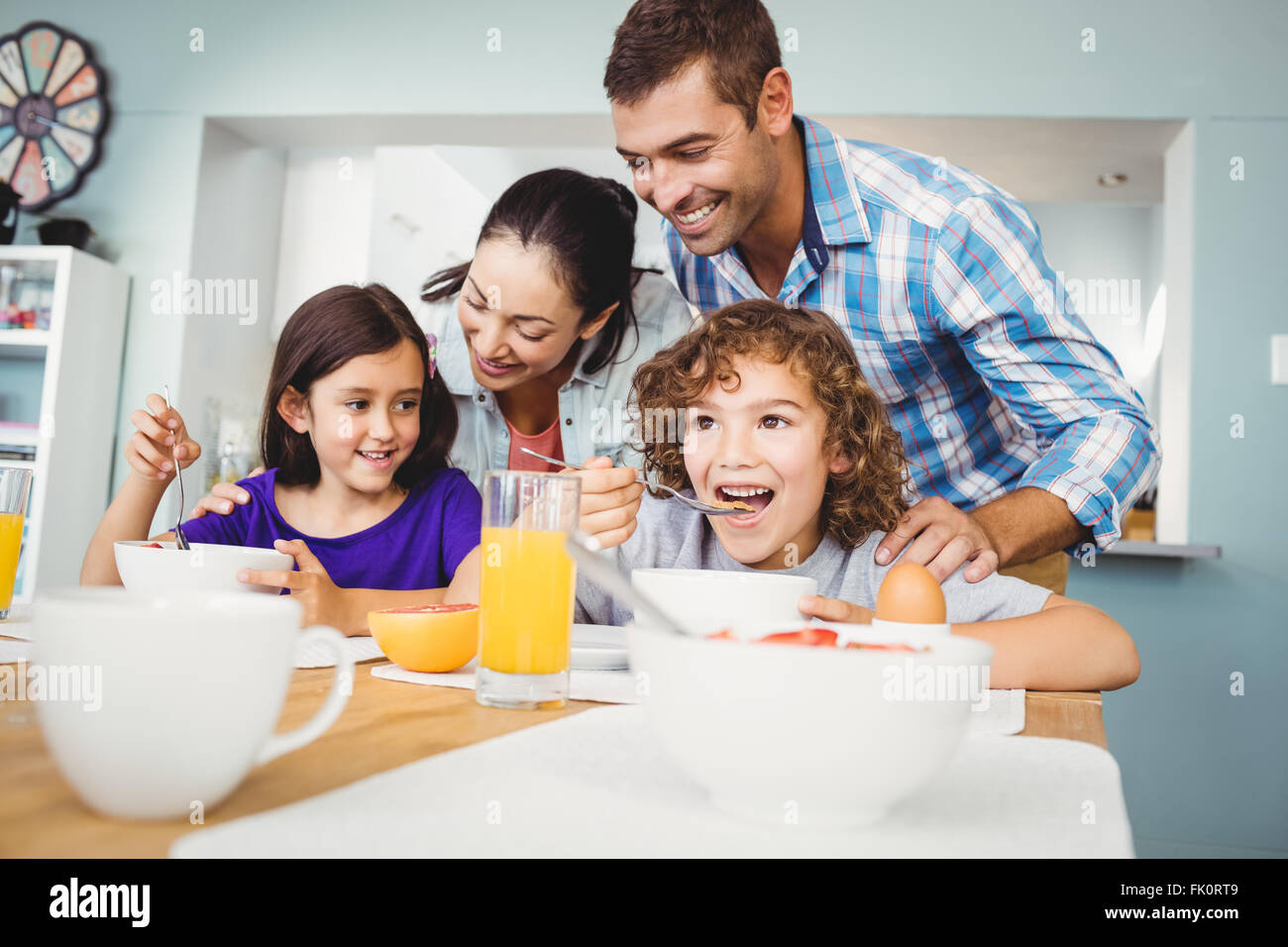 Fröhlicher Mensch und Frau mit den Kindern während des Frühstücks Stockfoto