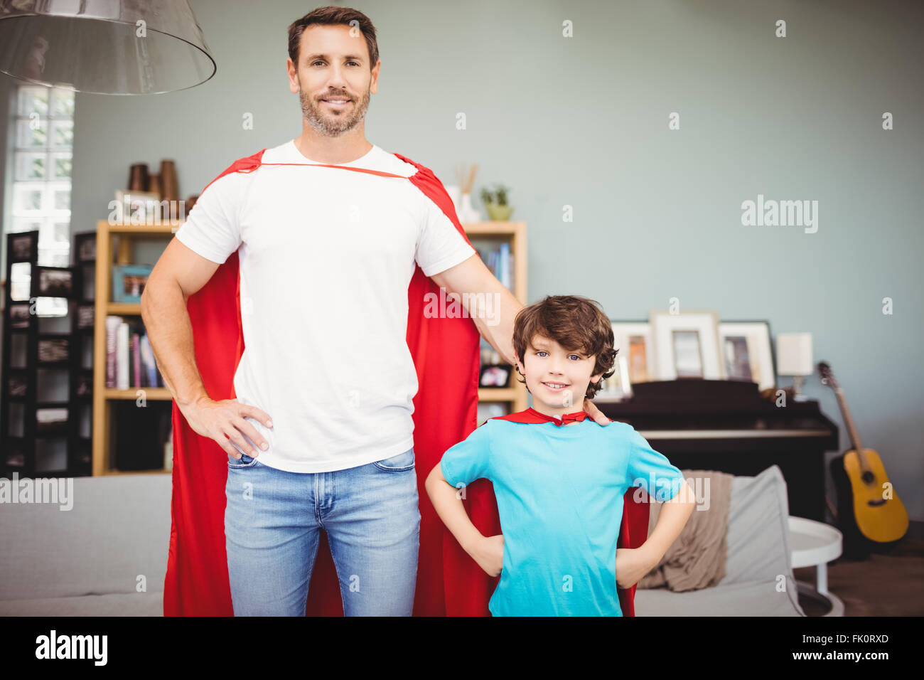 Porträt des Lächelns, Vater und Sohn in Superhelden-Kostüm Stockfoto