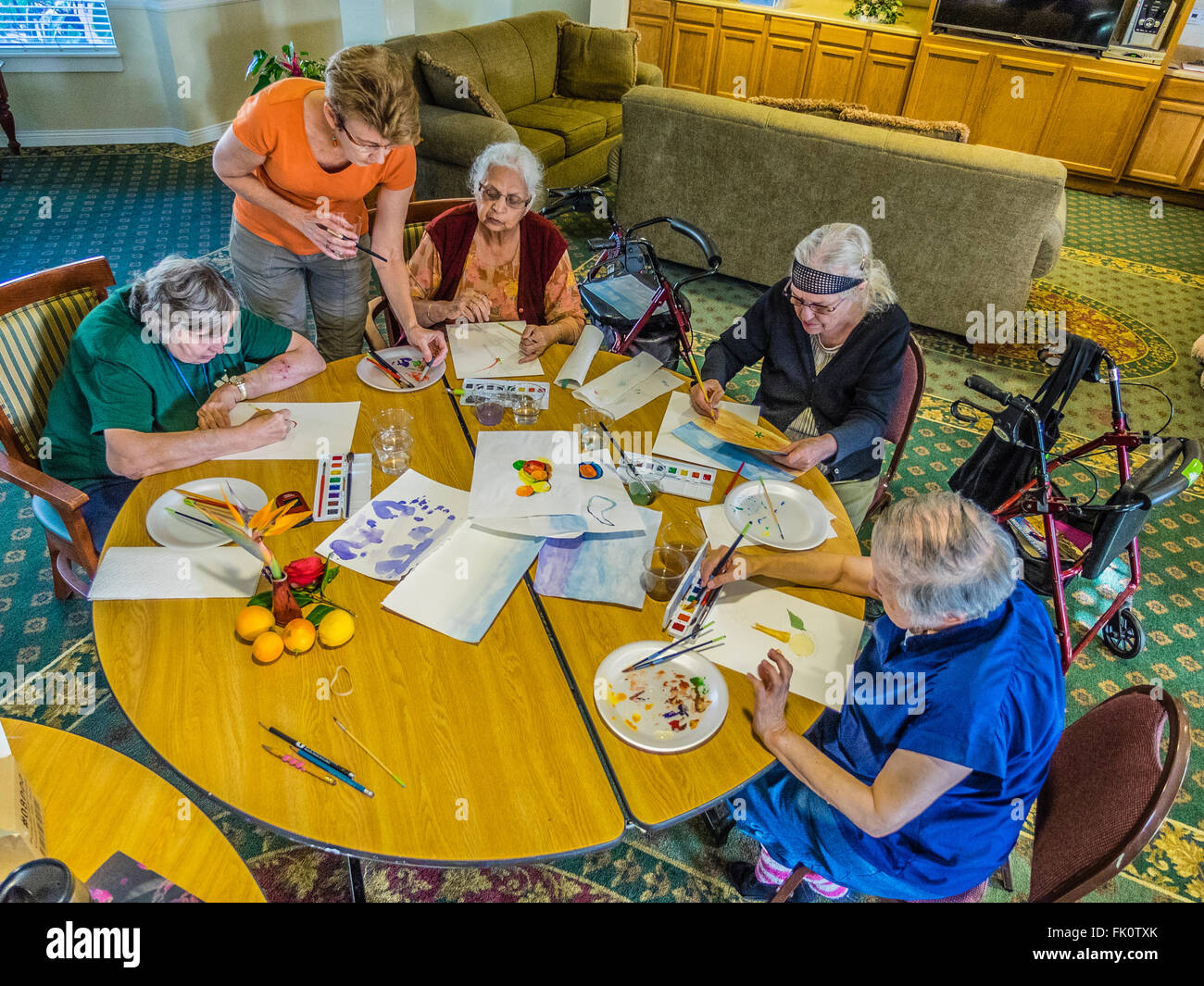 Ein Lehrer hilft Seniorinnen malen in Aquarell-Klasse für Senioren in einem Seniorenzentrum in Santa Barbara, Kalifornien. Stockfoto