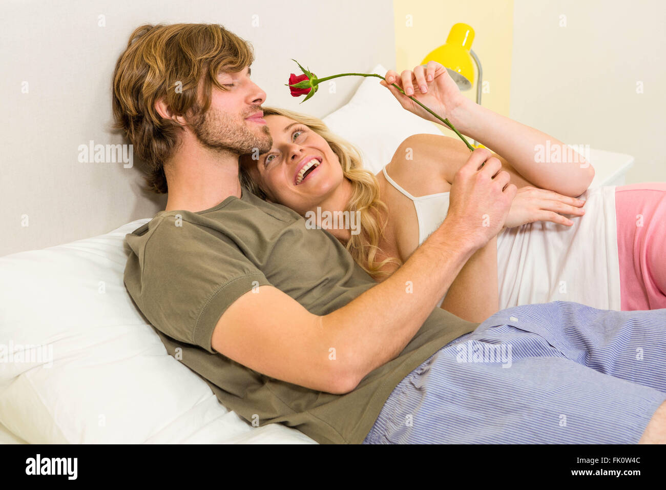 Süßes Paar kuscheln mit Freund riechen eine rose Stockfoto