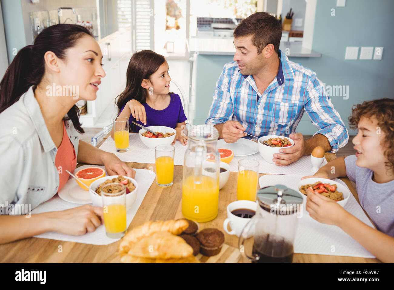 Glückliche Familie im Gespräch beim Frühstück Stockfoto