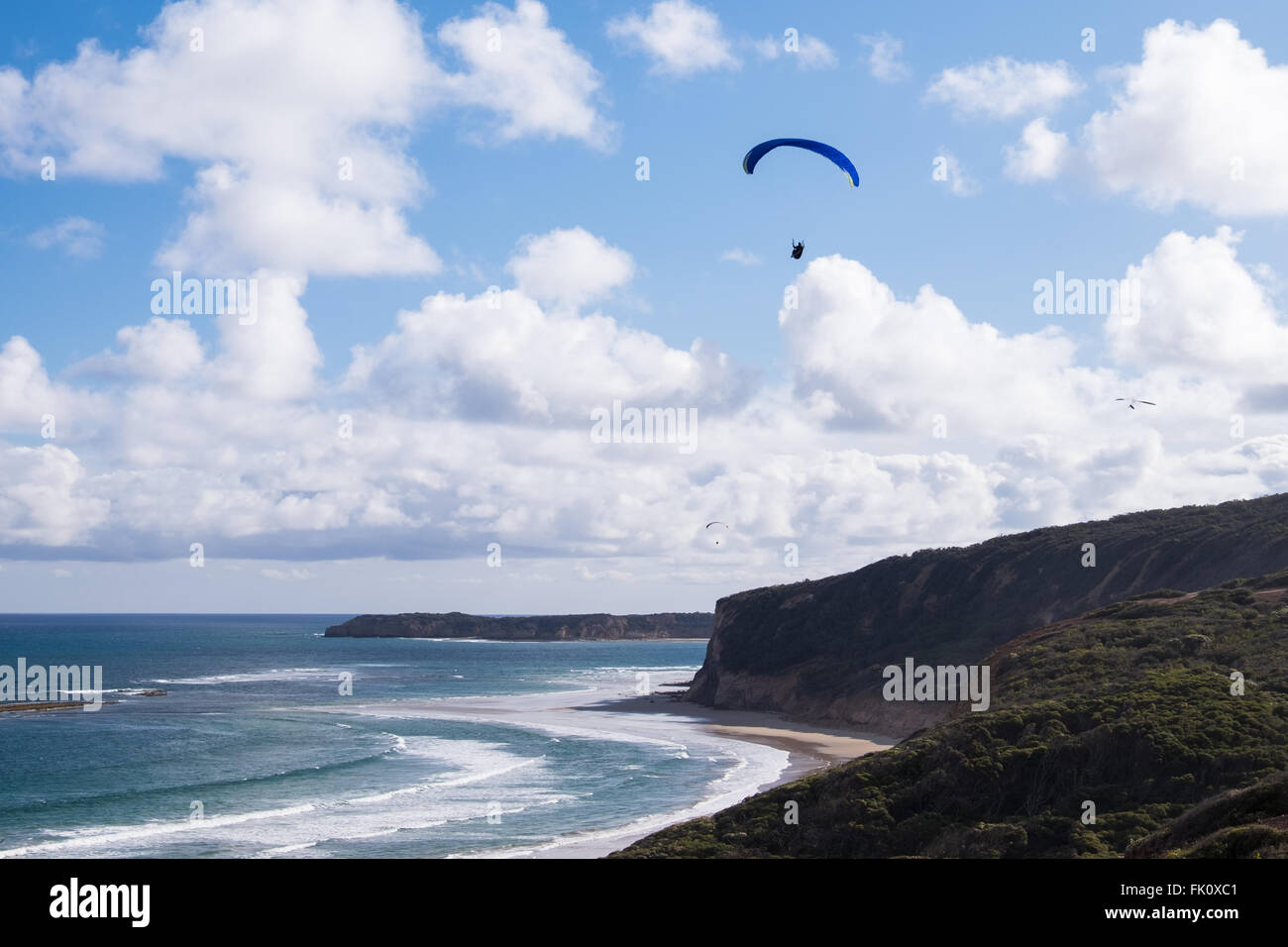 Ein Gleitschirm und Hängegleiter fliegen über Southside Beach, in der Nähe von Bells Beach in Torquay, Victoria, Australien Stockfoto